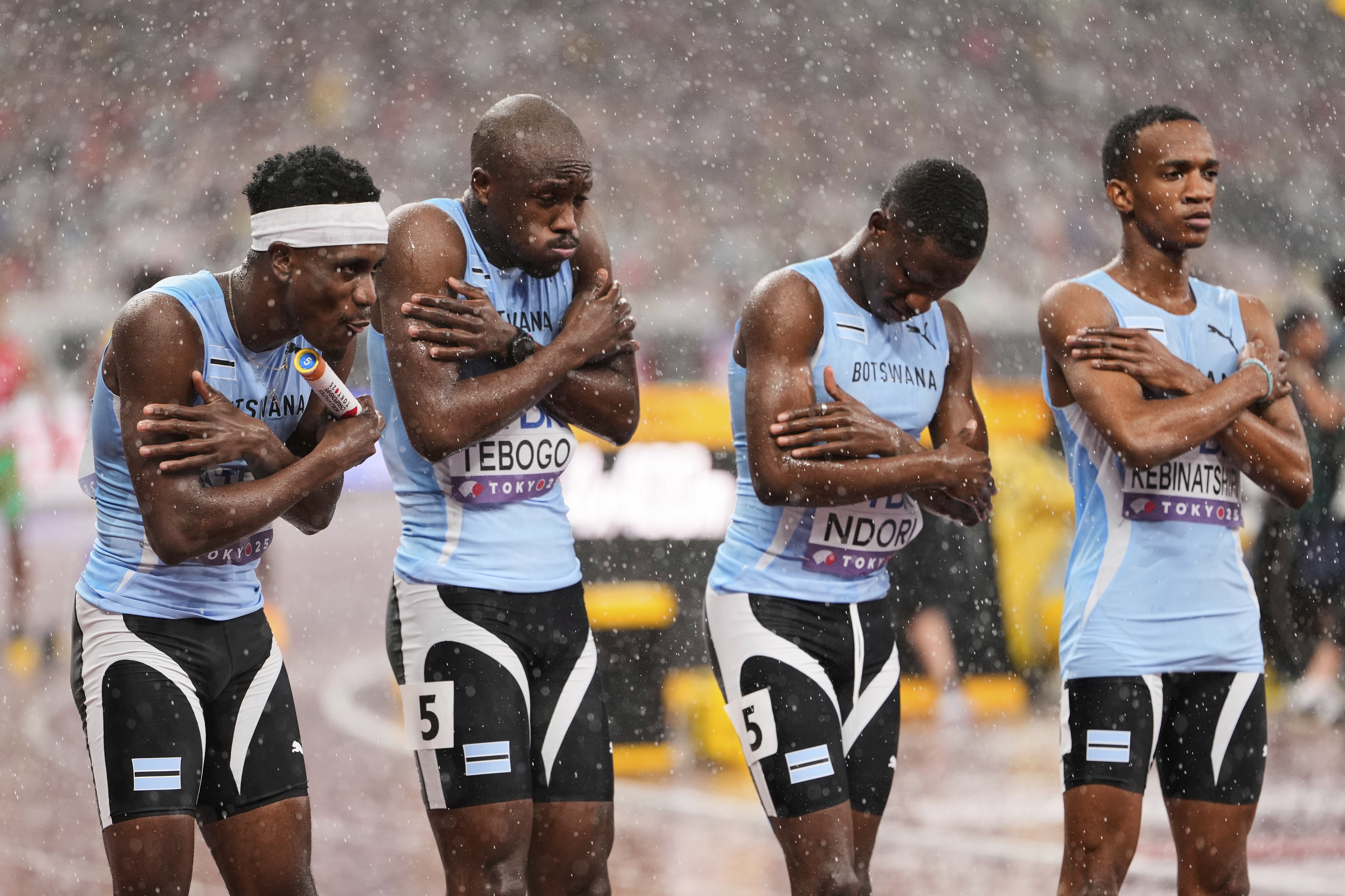 Team Botswana react to the cold rain before the start of the men's 4 X 400 meters relay at the World Athletics Championships in Tokyo, Sunday, Sept. 21, 2025. (Eugene Hoshiko - AP)
