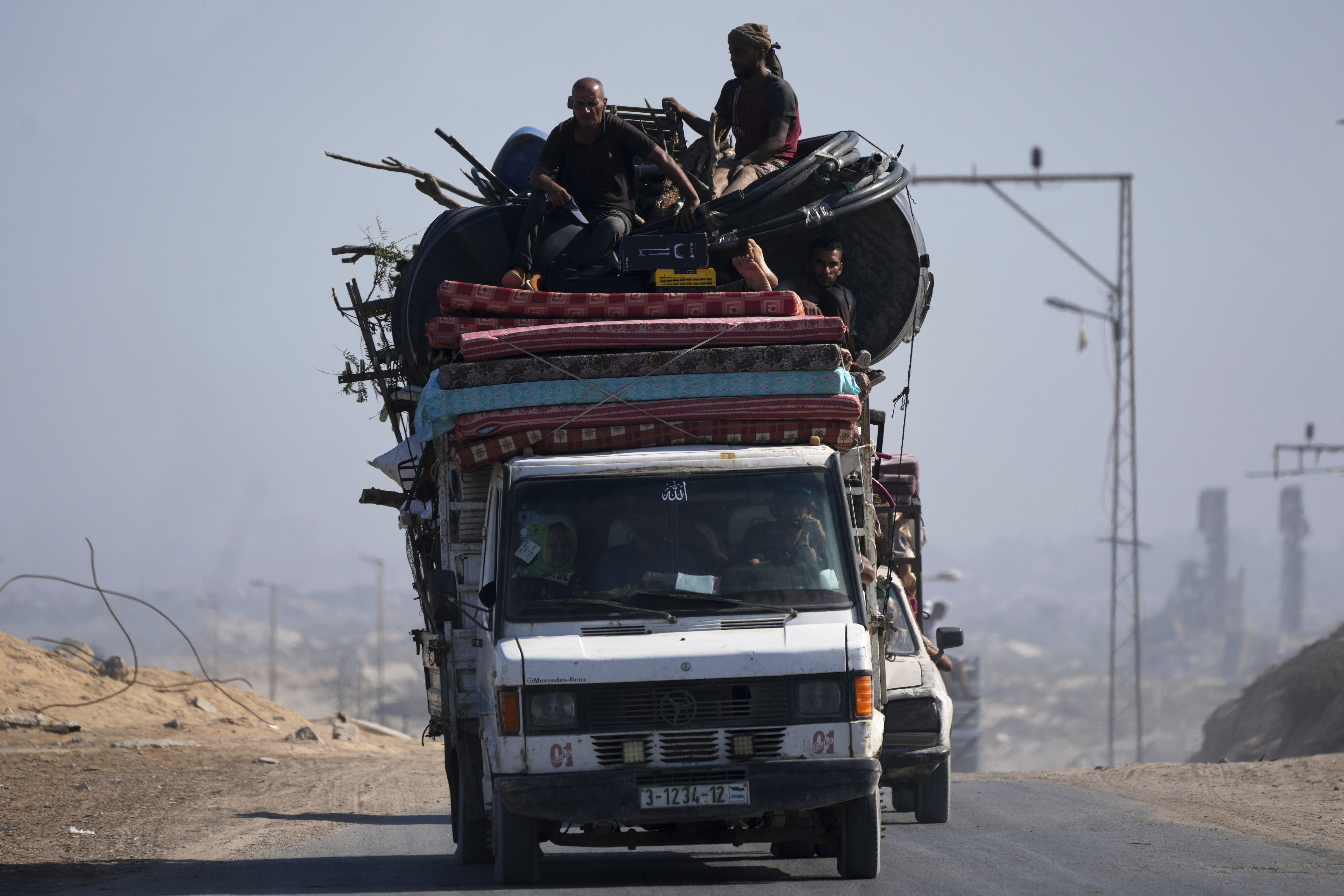 Displaced Palestinians fleeing northern Gaza carry their belongings in a car along the coastal road toward southern Gaza, Tuesday, Sept. 9, 2025, after the Israeli army issued evacuation orders from Gaza City. (Jehad Alshrafi - AP)