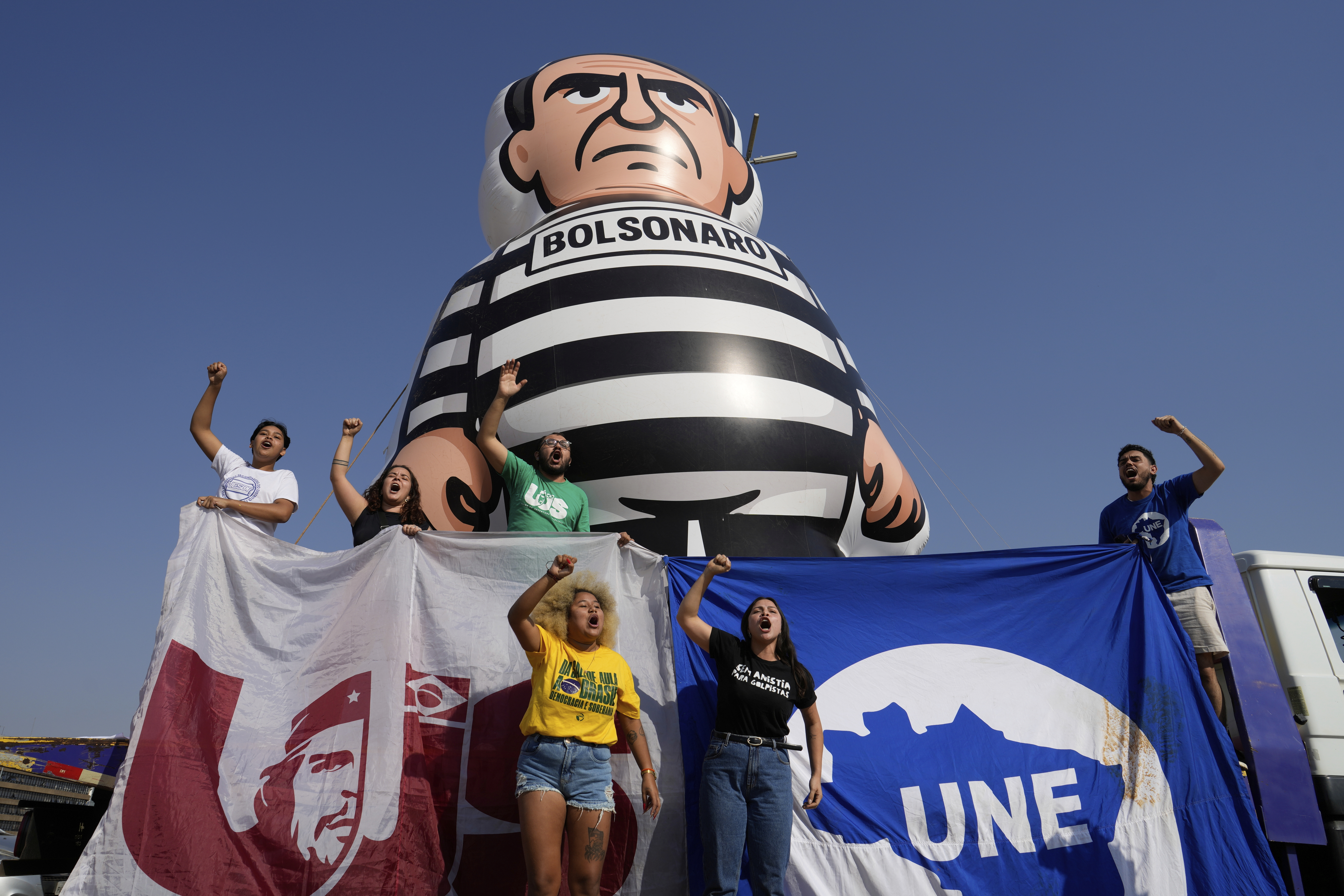 University students display an inflatable doll of Brazil's former President Jair Bolsonaro wearing prisoner garb in Brasilia, Brazil, Friday, Sept. 12, 2025, the morning after the Supreme Court convicted and sentenced him to prison for attempting a coup to remain in office despite his 2022 electoral defeat. (Eraldo Peres - AP)