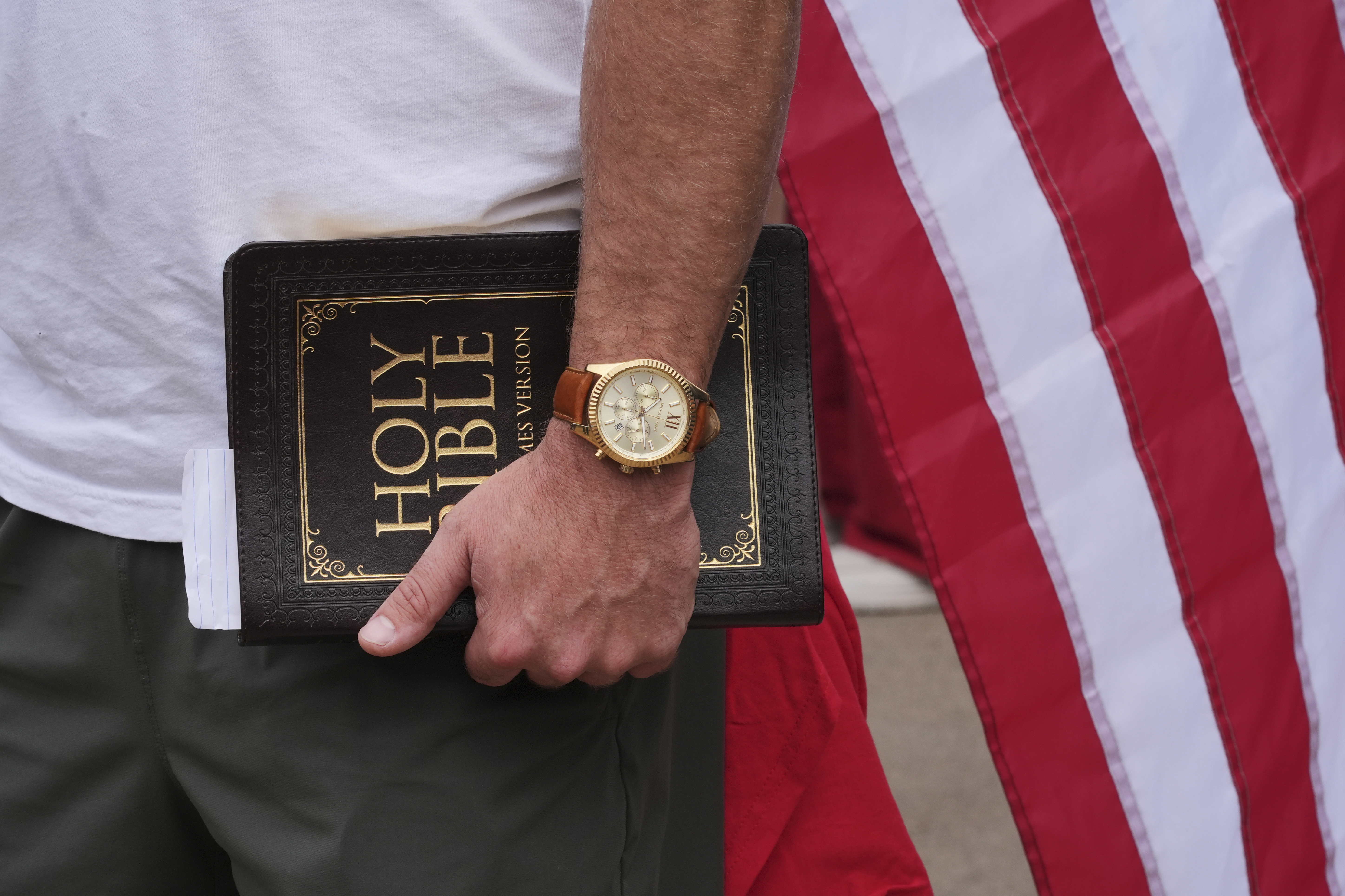 A man holds a Bible outside before a memorial for conservative activist Charlie Kirk, Sunday, Sept. 21, 2025, at State Farm Stadium in Glendale, Ariz. (Jae C. Hong - AP)