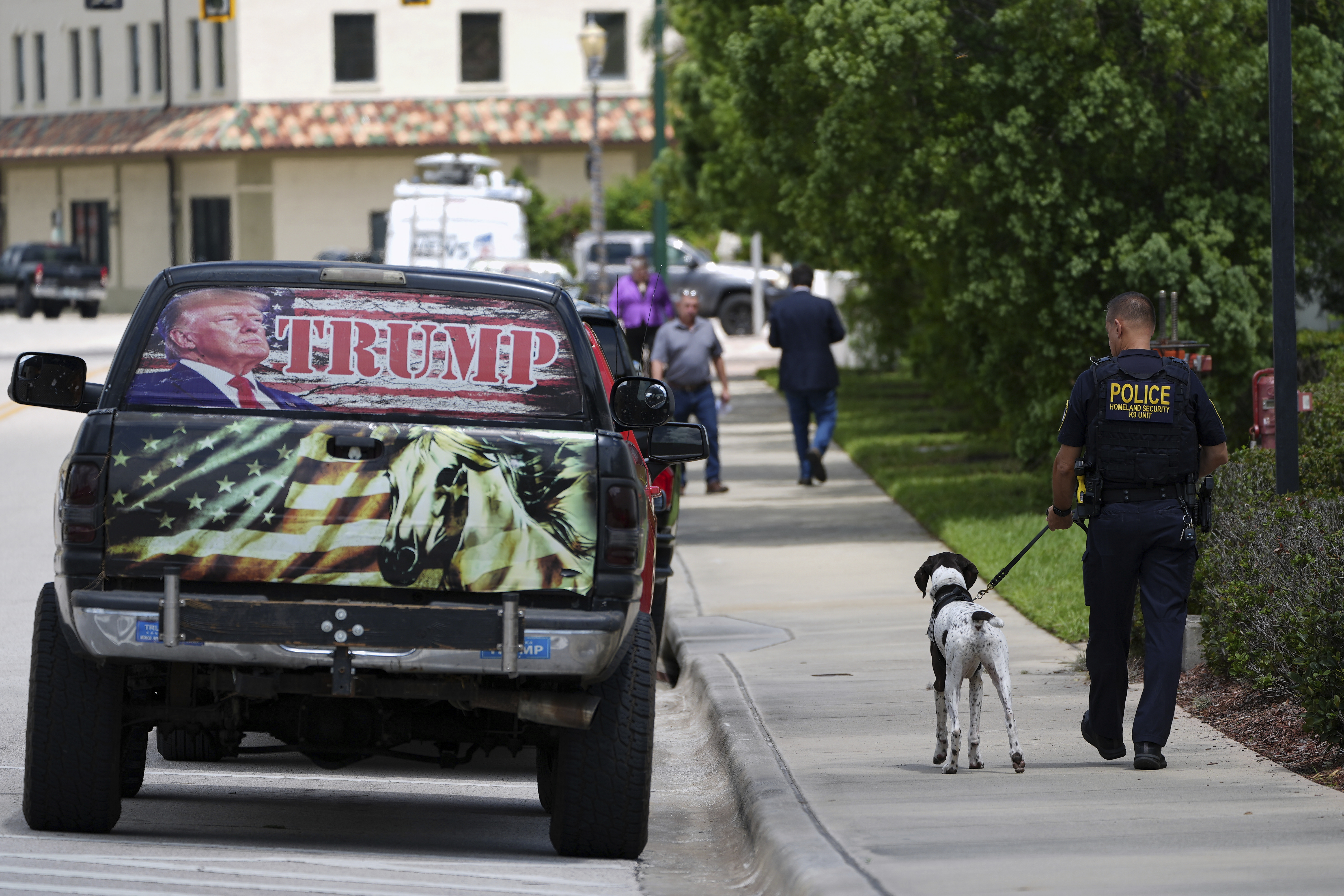 A Department of Homeland Security K9 unit officer walks past a truck decorated in support of President Donald Trump, as he works with a dog trained to detect explosives outside the Alto Lee Adams Sr. U.S. Courthouse after the start of jury selection in the trial of Ryan Routh, charged with trying to assassinate Trump while he played golf last year in South Florida, Monday, Sept. 8, 2025, in Fort Pierce, Fla. (Rebecca Blackwell - AP)