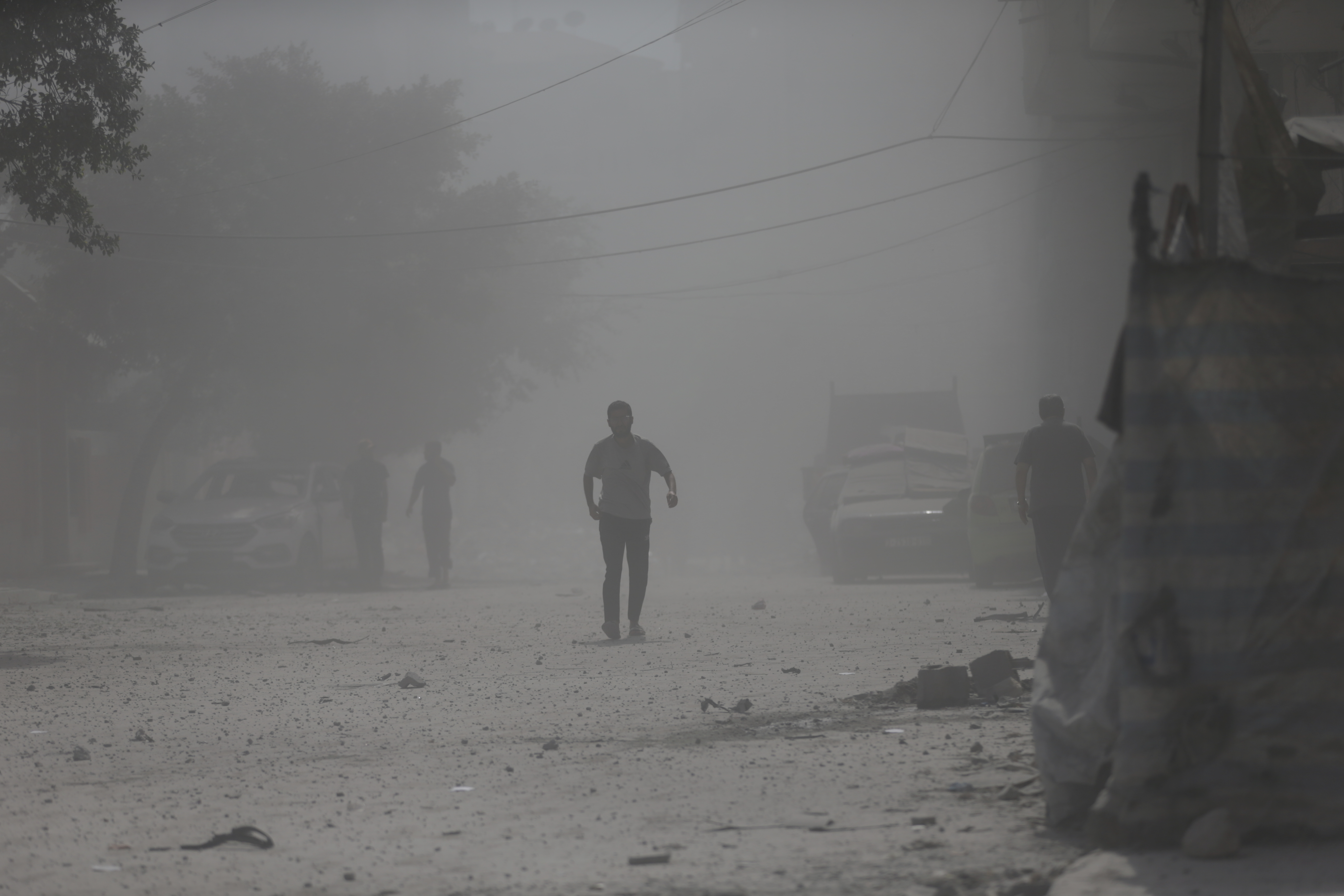 Palestinians walk through dust moments after an Israeli military strike that destroyed a building in Gaza City, Monday, Sept. 15, 2025. (Yousef Al Zanoun - AP)
