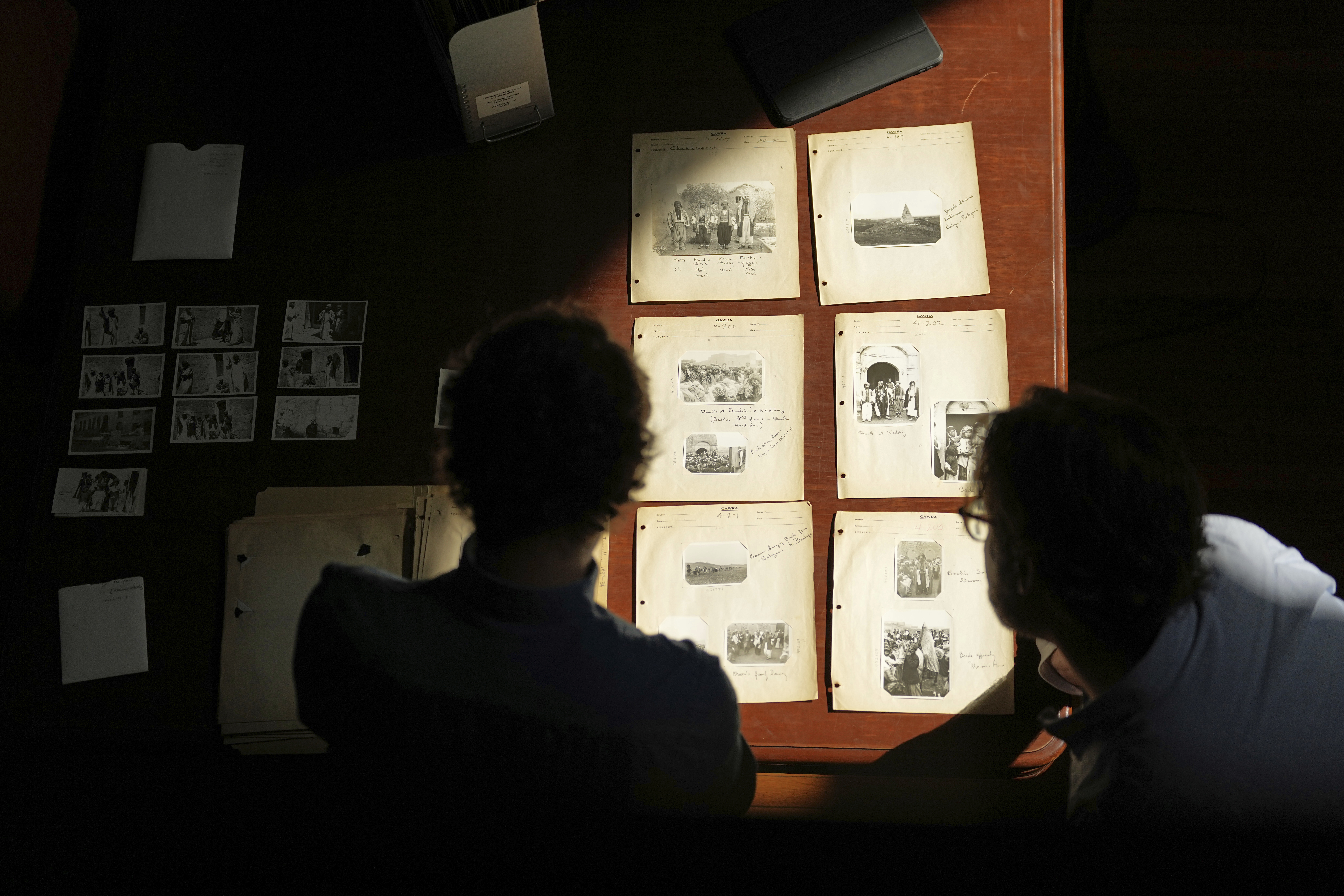 University of Pennsylvania doctoral student Marc Marin Webb, left, and University of Victoria postdoctoral fellow Nathaniel Brunt, view images of photos of the Yazidi people in their northern Iraq homeland in the 1930s, during an interview at the Penn Museum Archives in Philadelphia, Aug. 27, 2025. (Matt Rourke - AP)