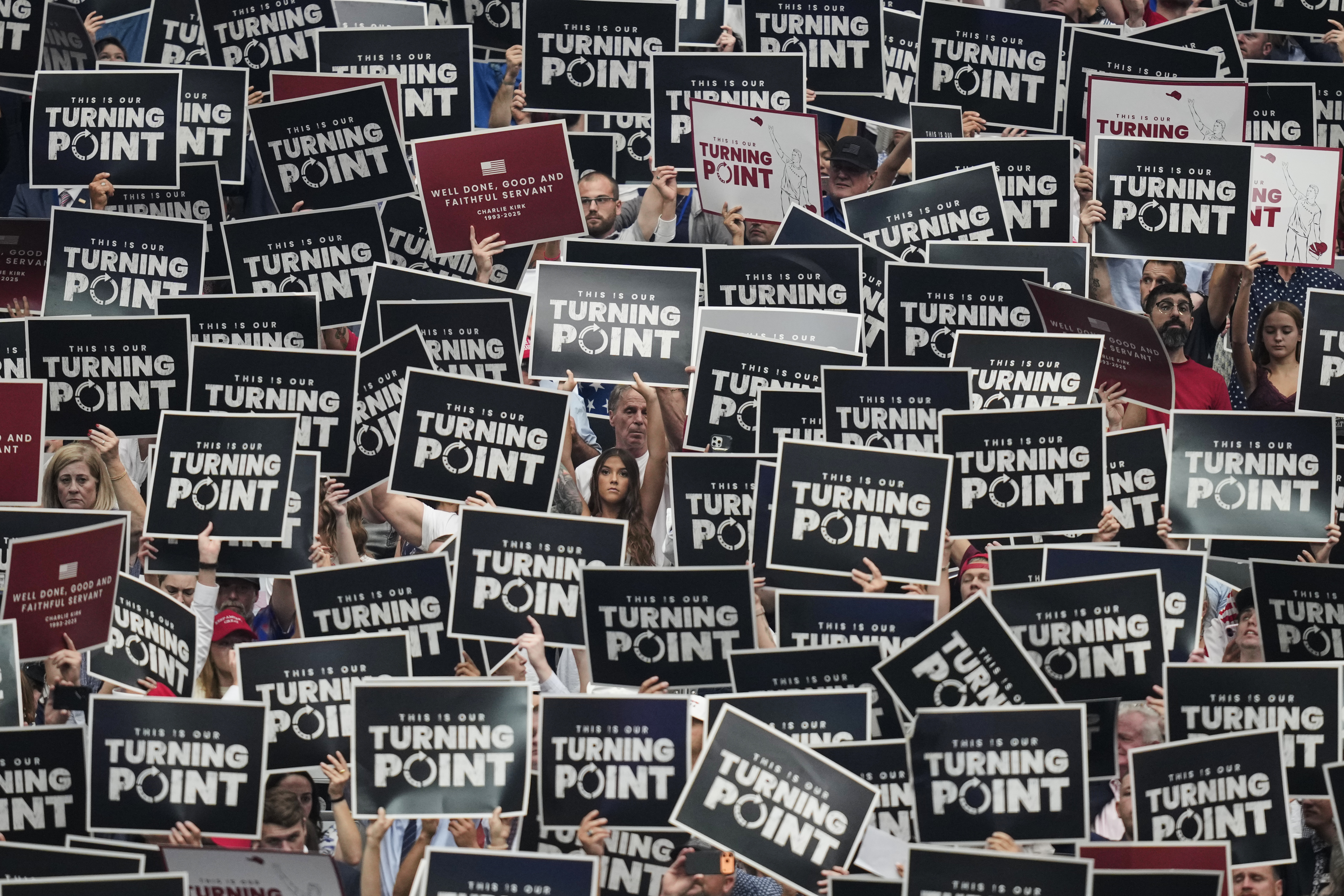 People hold up signs during a memorial for conservative activist Charlie Kirk, Sunday, Sept. 21, 2025, at State Farm Stadium in Glendale, Ariz. (John Locher - AP)
