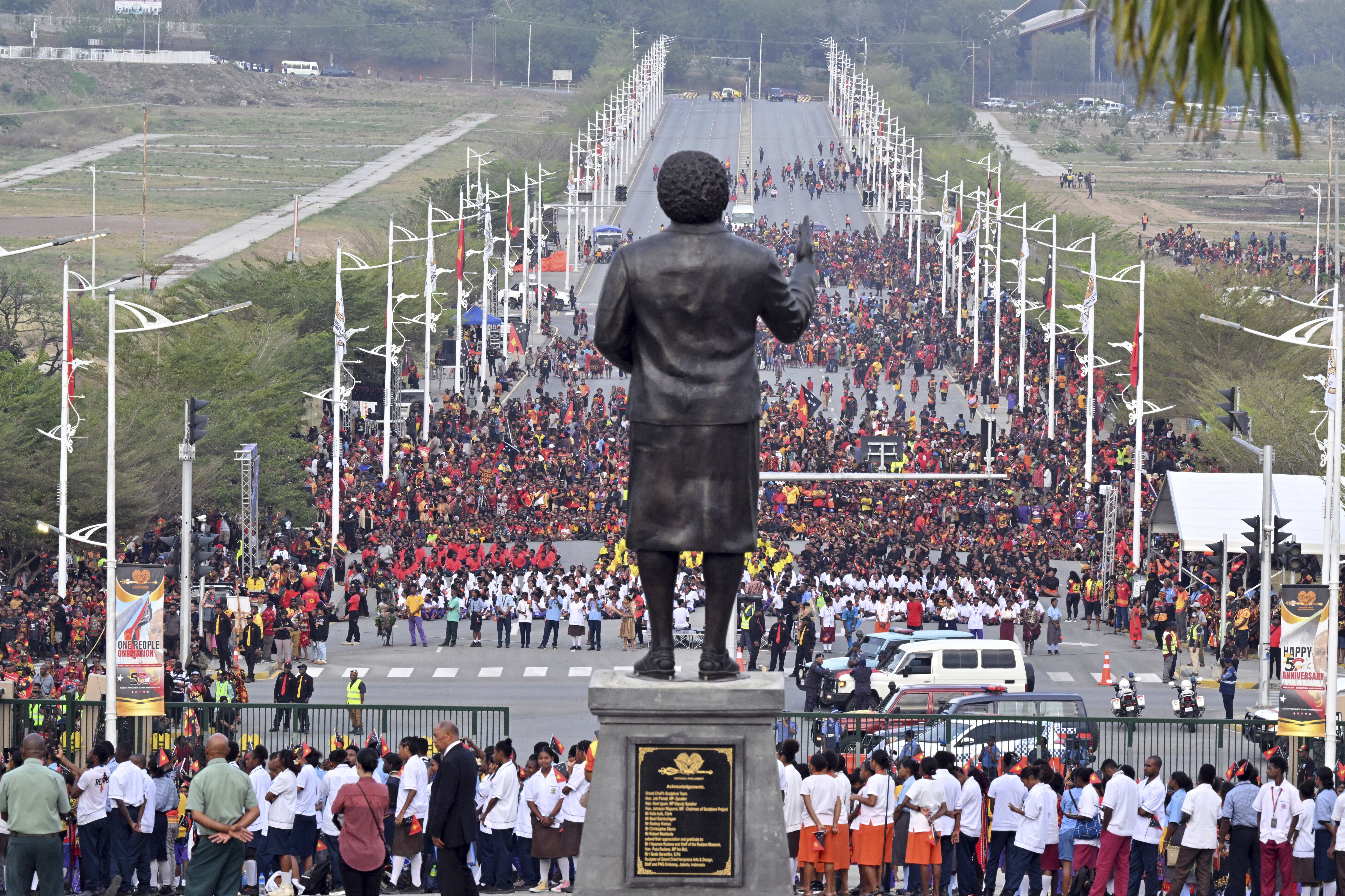 Papua New Guineans stand in front of a statue of Papua New Guinea's first Prime Minister Michael Somare during a flag raising ceremony at Parliament House in Port Moresby, Papua New Guinea, Tuesday, Sept. 16, 2025. (Mick Tsikas - AAP Image)
