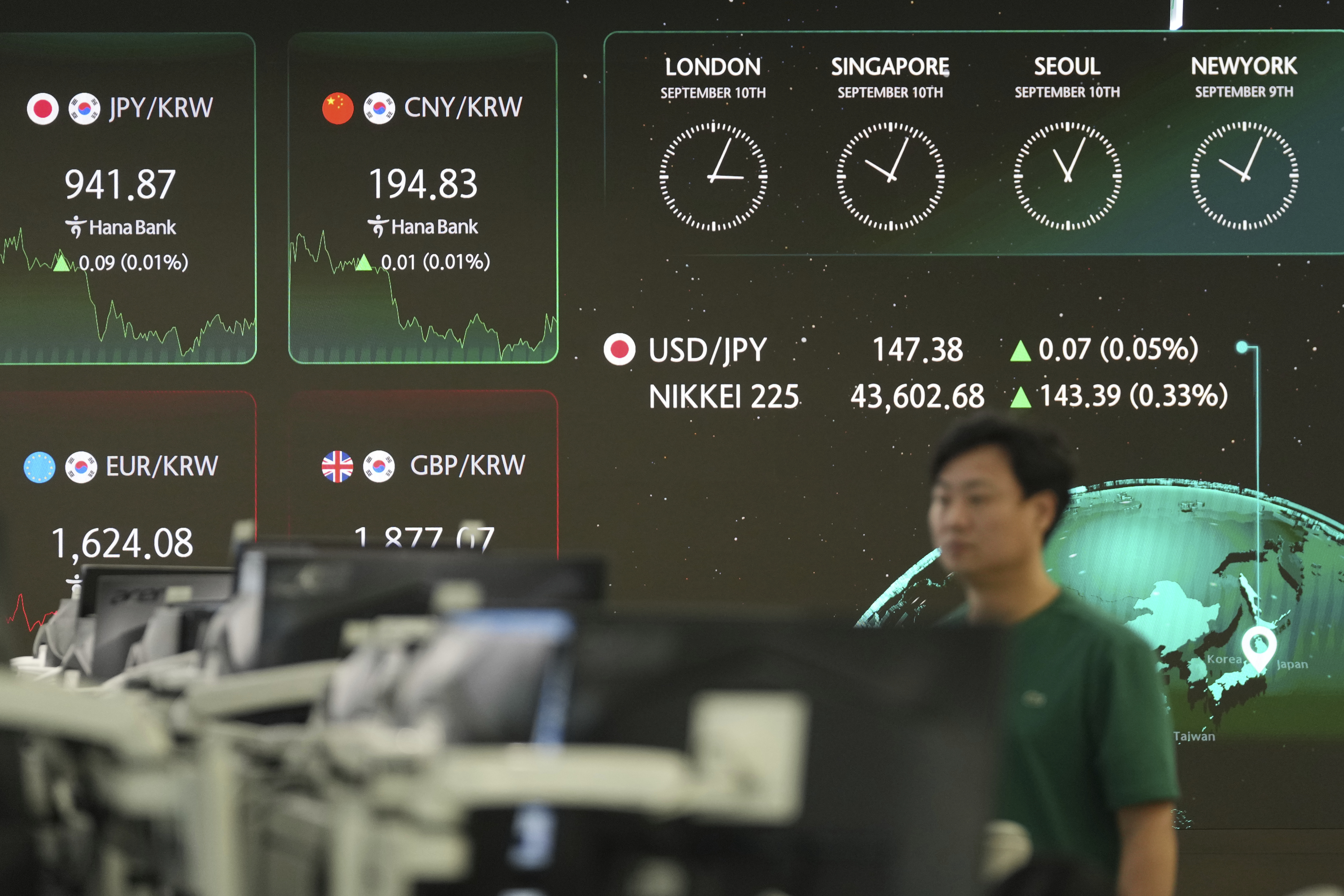 A dealer walks near the screens showing the foreign exchange rates at a dealing room of Hana Bank in Seoul, South Korea, Wednesday, Sept. 10, 2025. (Lee Jin-man - AP)