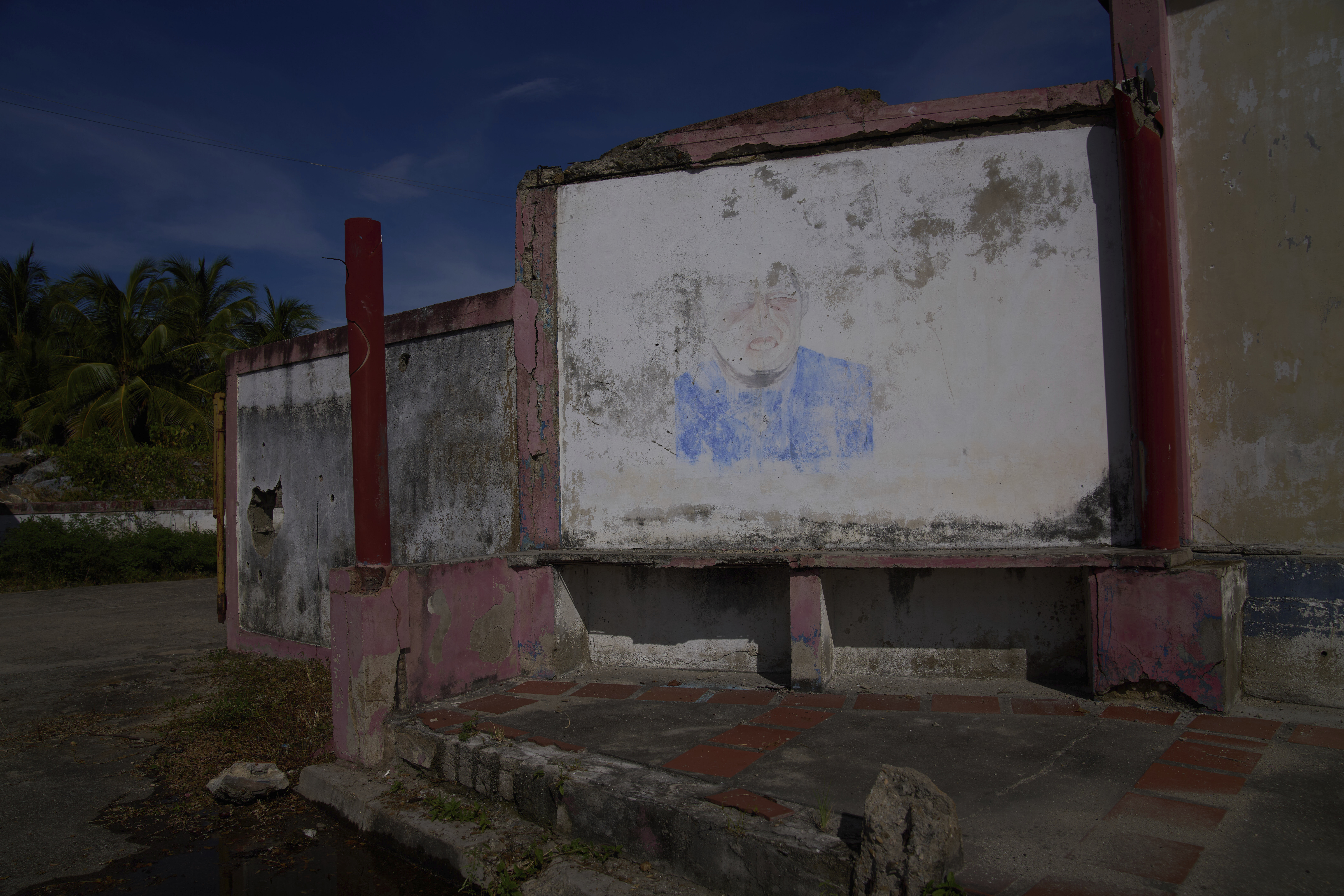 A barely visible mural of late President Hugo Chávez fades from a wall near the international port in Güiria, on Venezuela's Paria Peninsula, Saturday, Sept. 13, 2025. (Ariana Cubillos - AP)