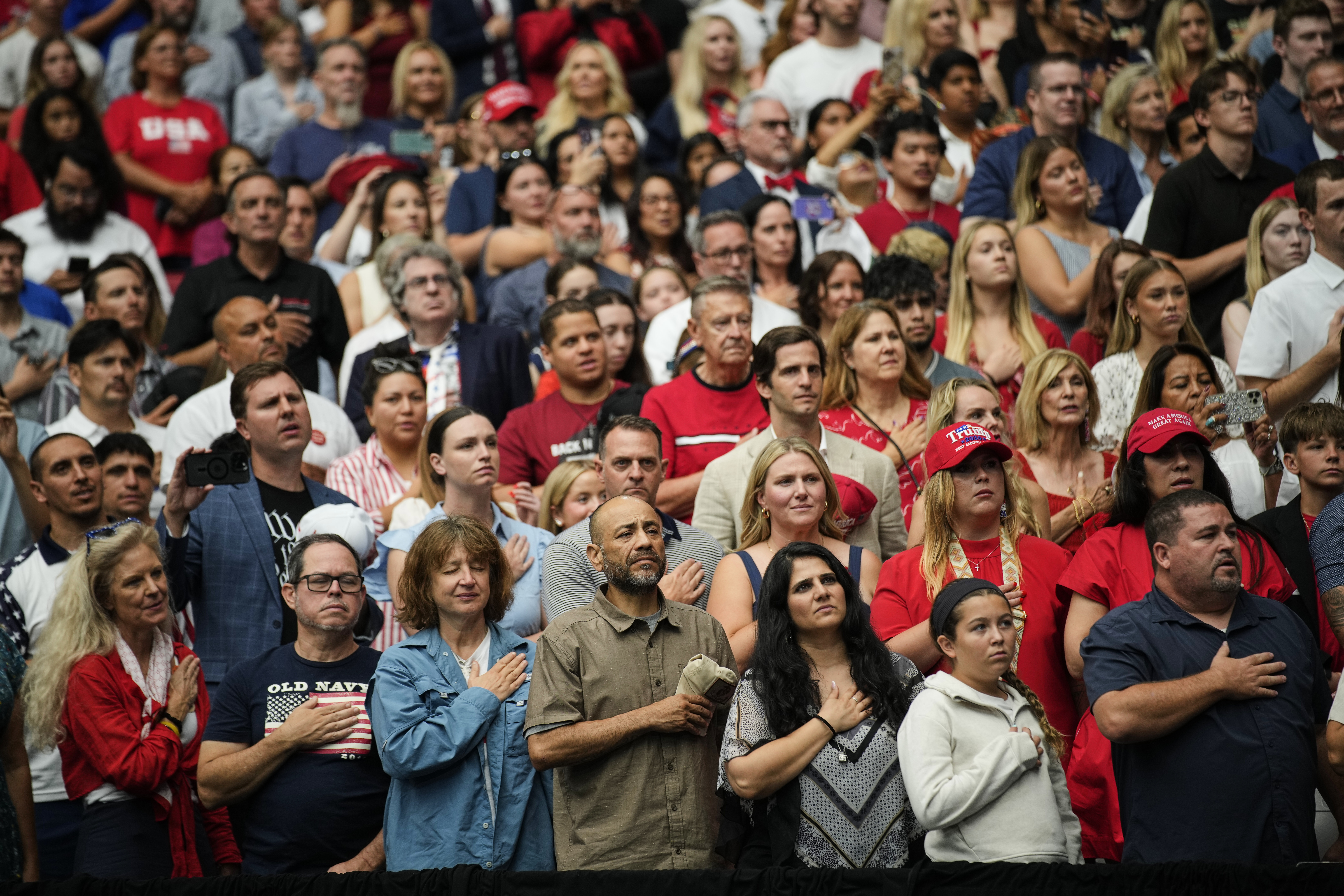 People stand for the singing of the national anthem at a memorial for conservative activist Charlie Kirk, Sunday, Sept. 21, 2025, at State Farm Stadium in Glendale, Ariz. (John Locher - AP)