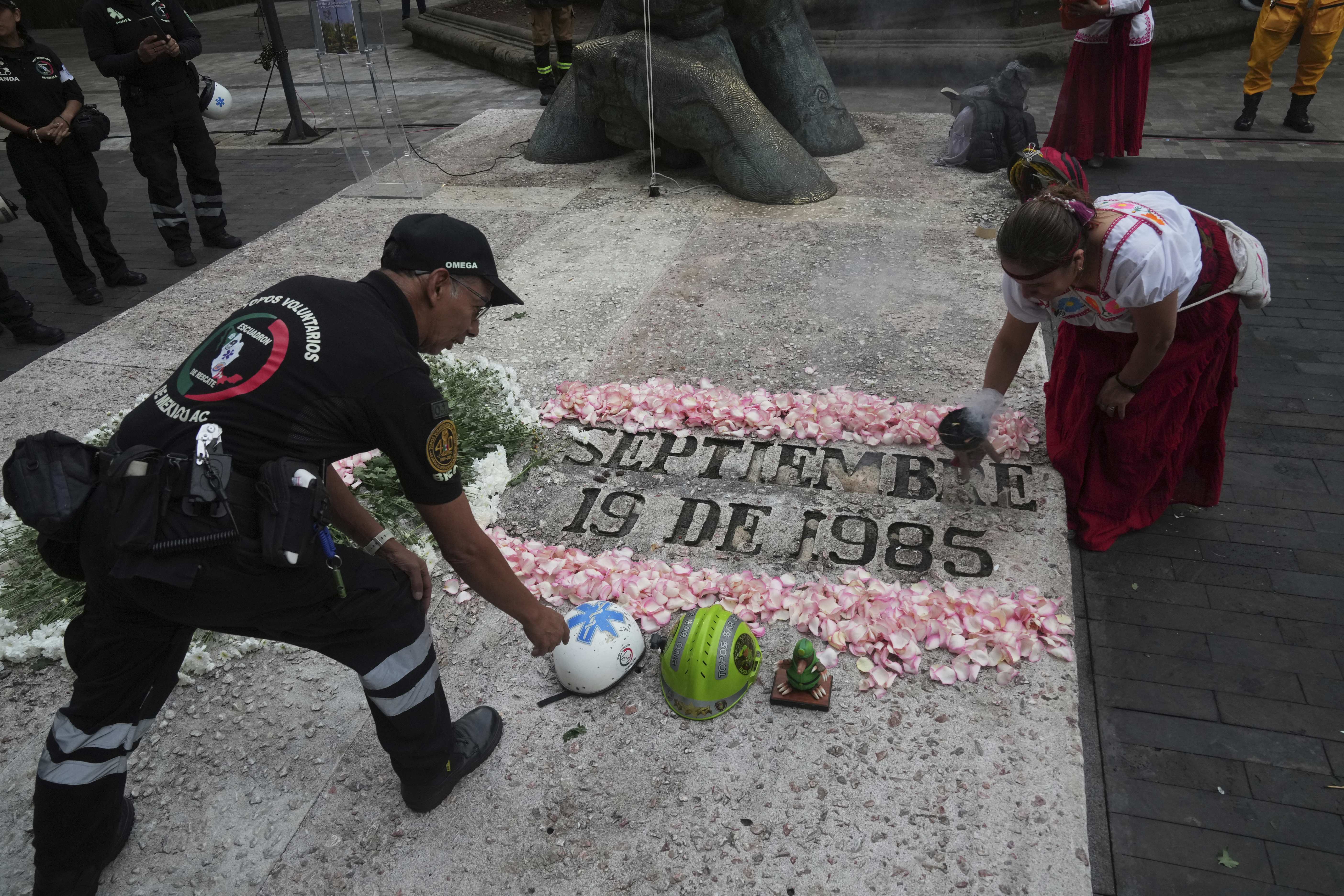 Francisco Camacho, of the Topos volunteer rescue workers brigade, left, and an Indigenous woman, attend a ceremony marking the 1985 earthquake's 40th anniversary in Mexico City, Friday, Sept. 19, 2025. (Marco Ugarte - AP)