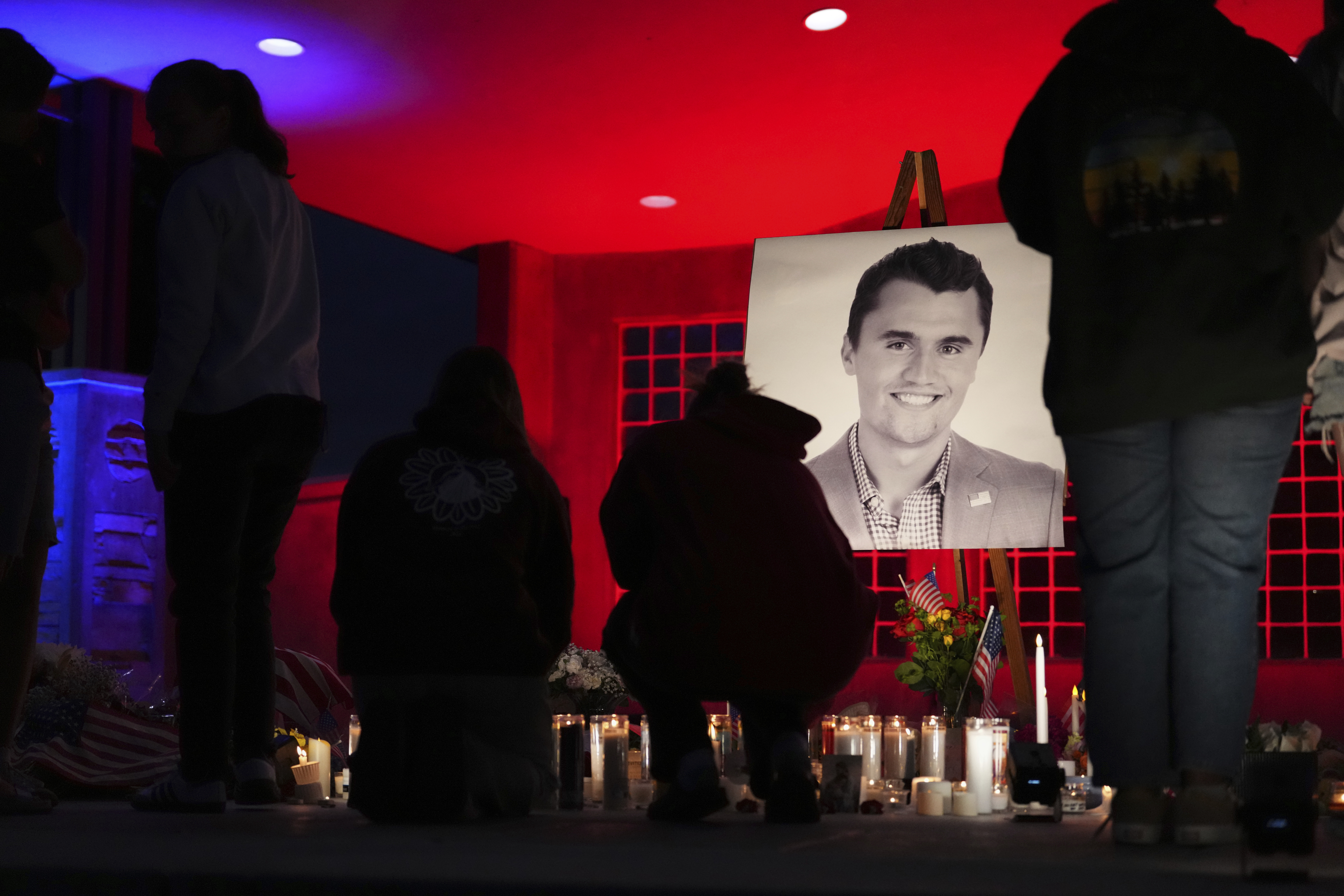 People place lit candles below a photo of Charlie Kirk, the CEO and co-founder of Turning Point USA who was shot and killed, at a vigil in his memory, Thursday, Sept. 11, 2025, in Orem, Utah. (Lindsey Wasson - AP)
