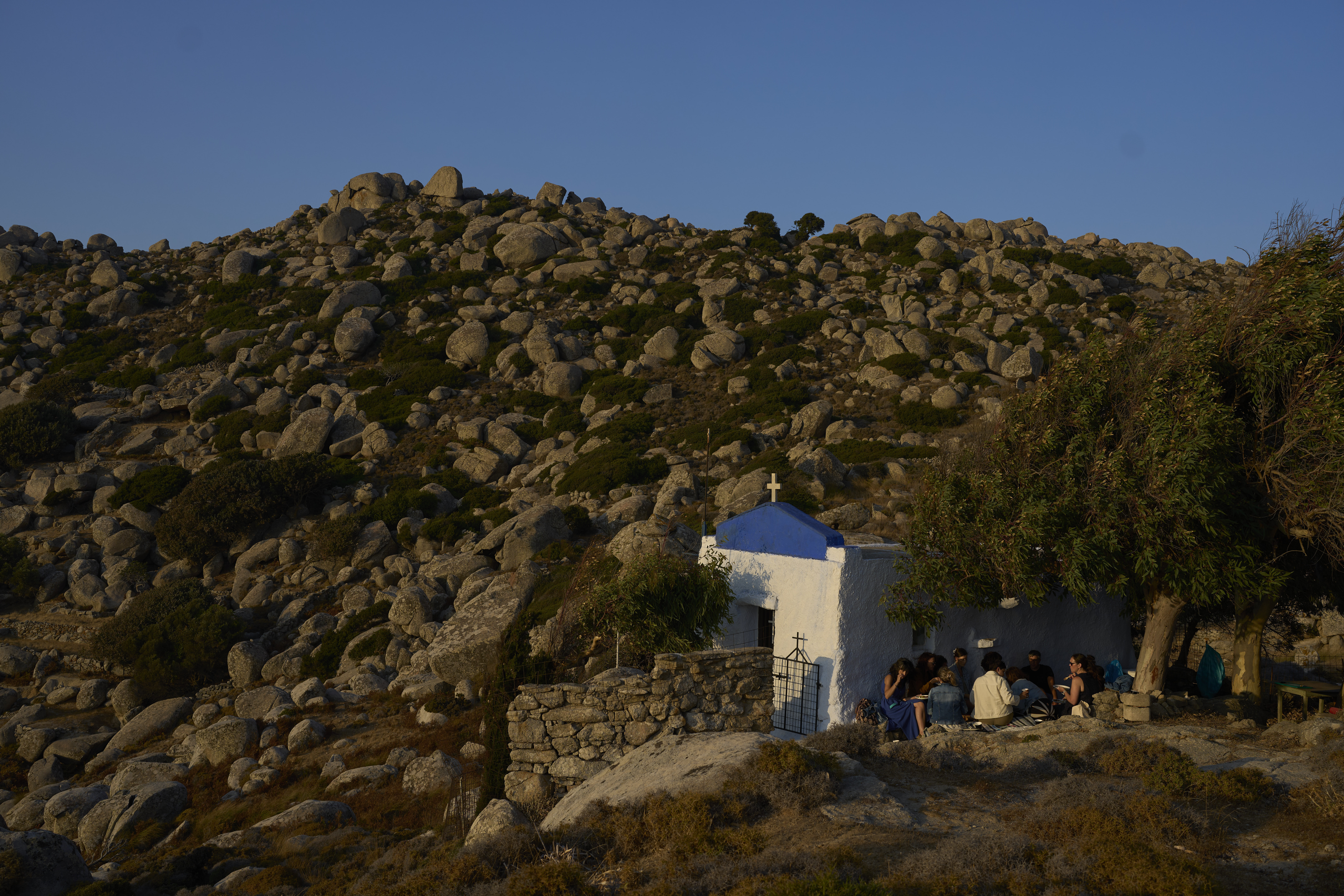 Tourists from the United States enjoy an organized picnic outside Agios Giorgos (St. George), a 200-year-old chapel near the village of Volax on Tinos island, Greece, Friday, Sept. 5, 2025. (Petros Giannakouris - AP)