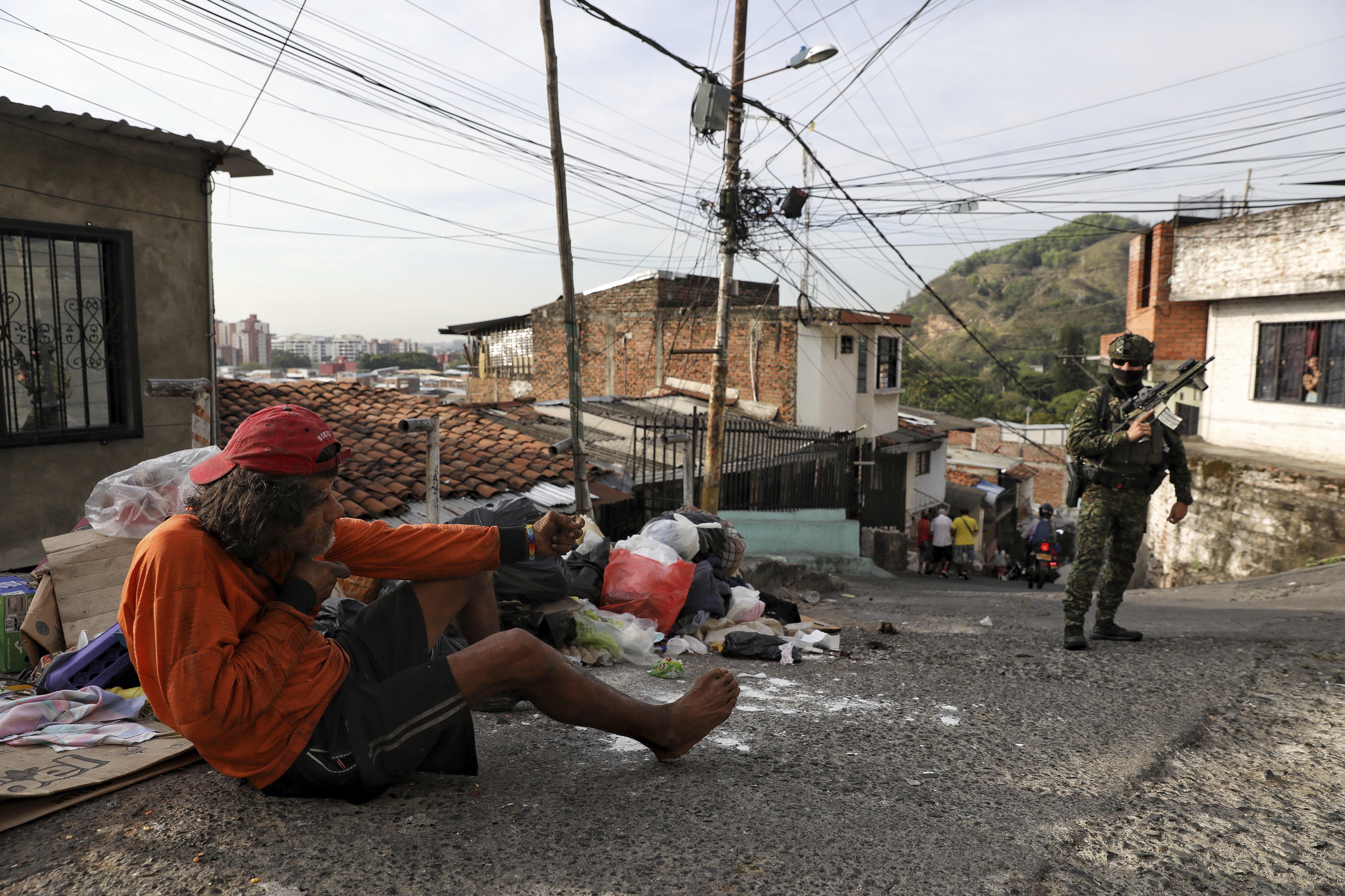 A man mocks a soldier patrolling the Siloé neighborhood in Cali, Colombia, Thursday, Sept. 11, 2025. (Santiago Saldarriaga - AP)