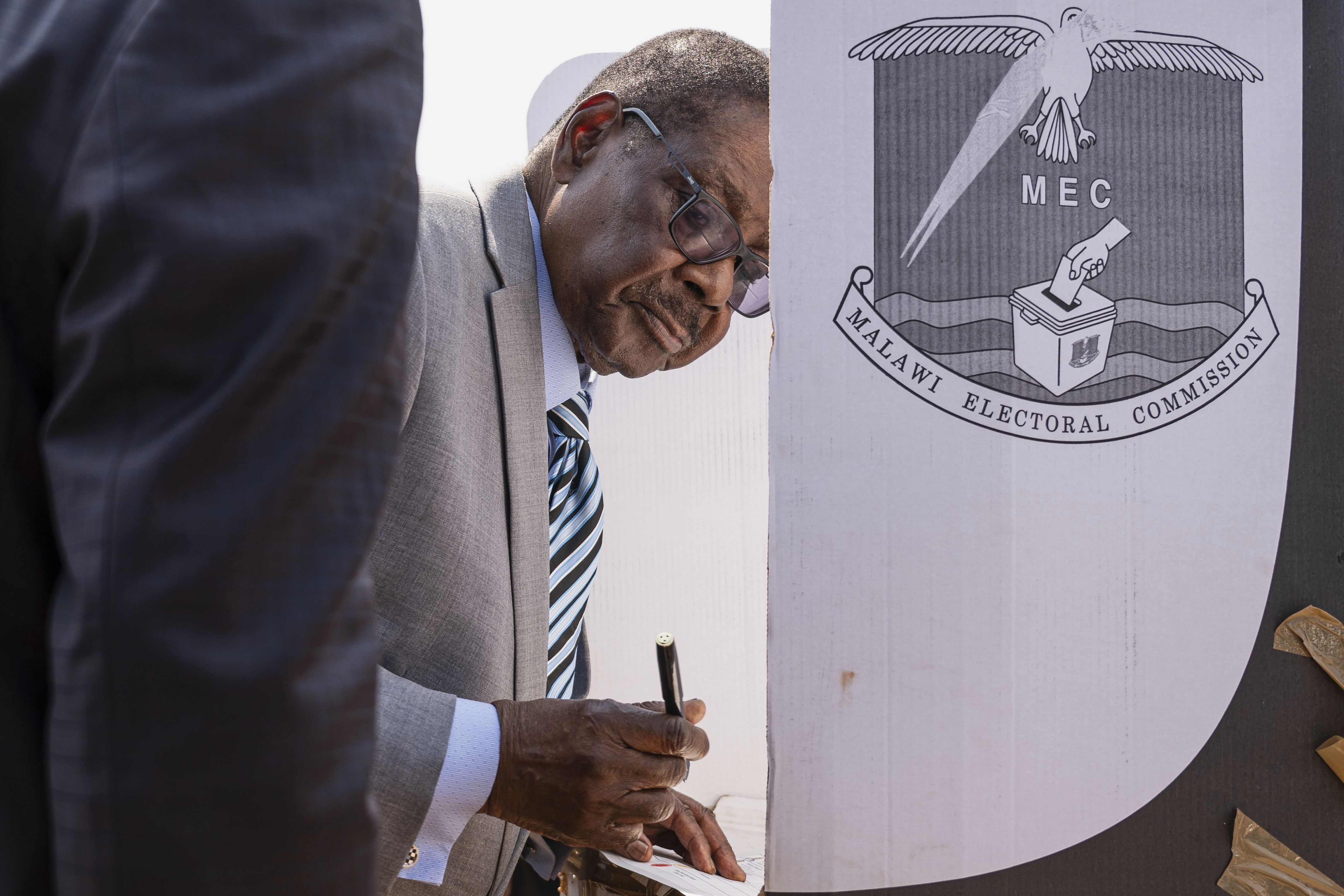 Malawi's presidential candidate, former President Peter Mutharika stands on a voting booth as he prepares to cast his vote in Thyolo District, Malawi, Tuesday, Sept. 16, 2025. (Thoko Chikondi - AP)