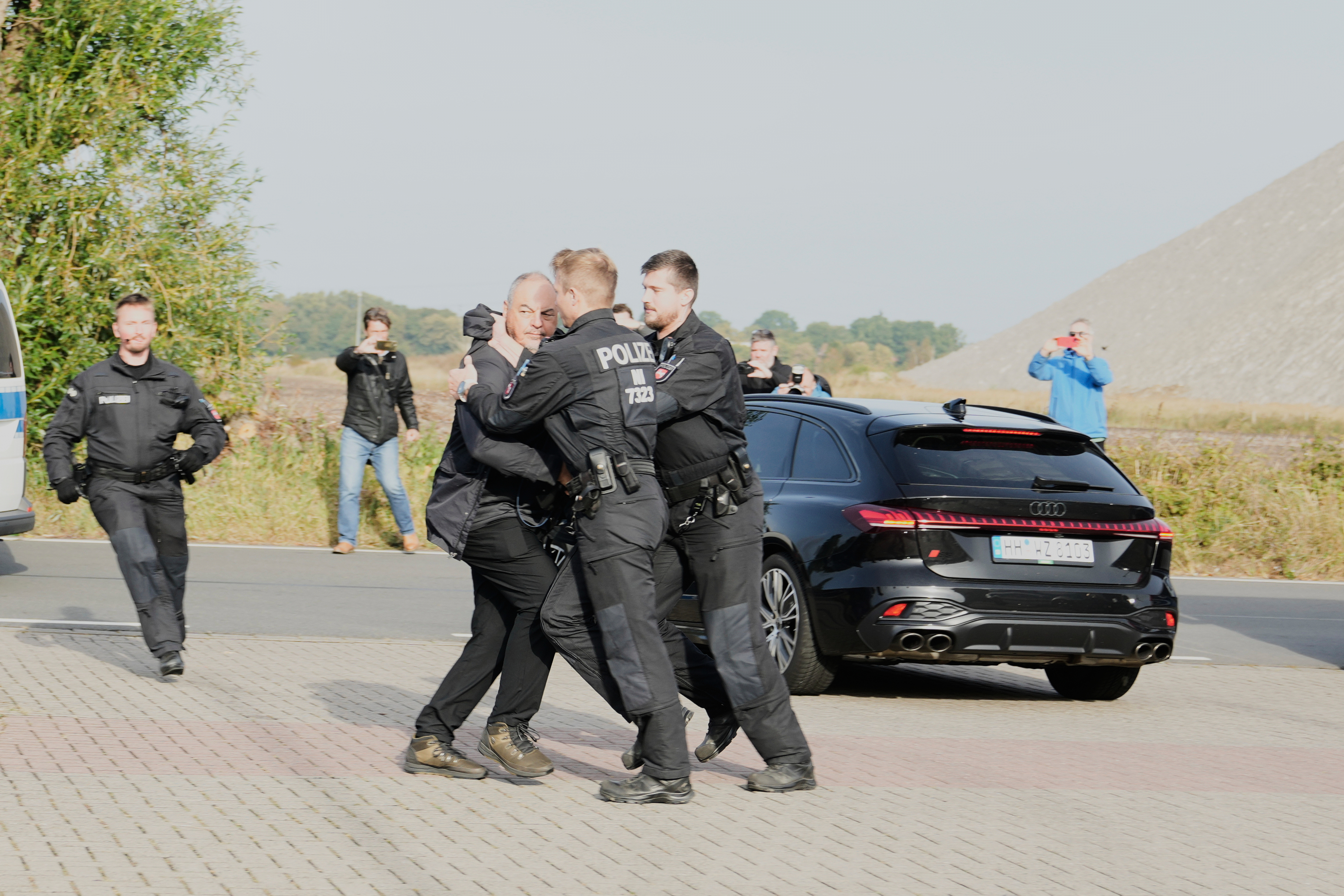 Police officers push back a British photographer who tried to take pictures inside a car leaving a prison, carrying Christian B., a suspect in the 2007 disappearance of British toddler Madeleine McCann, in Sehnde, Germany, Wednesday, Sept. 17, 2025. (Markus Schreiber - AP)
