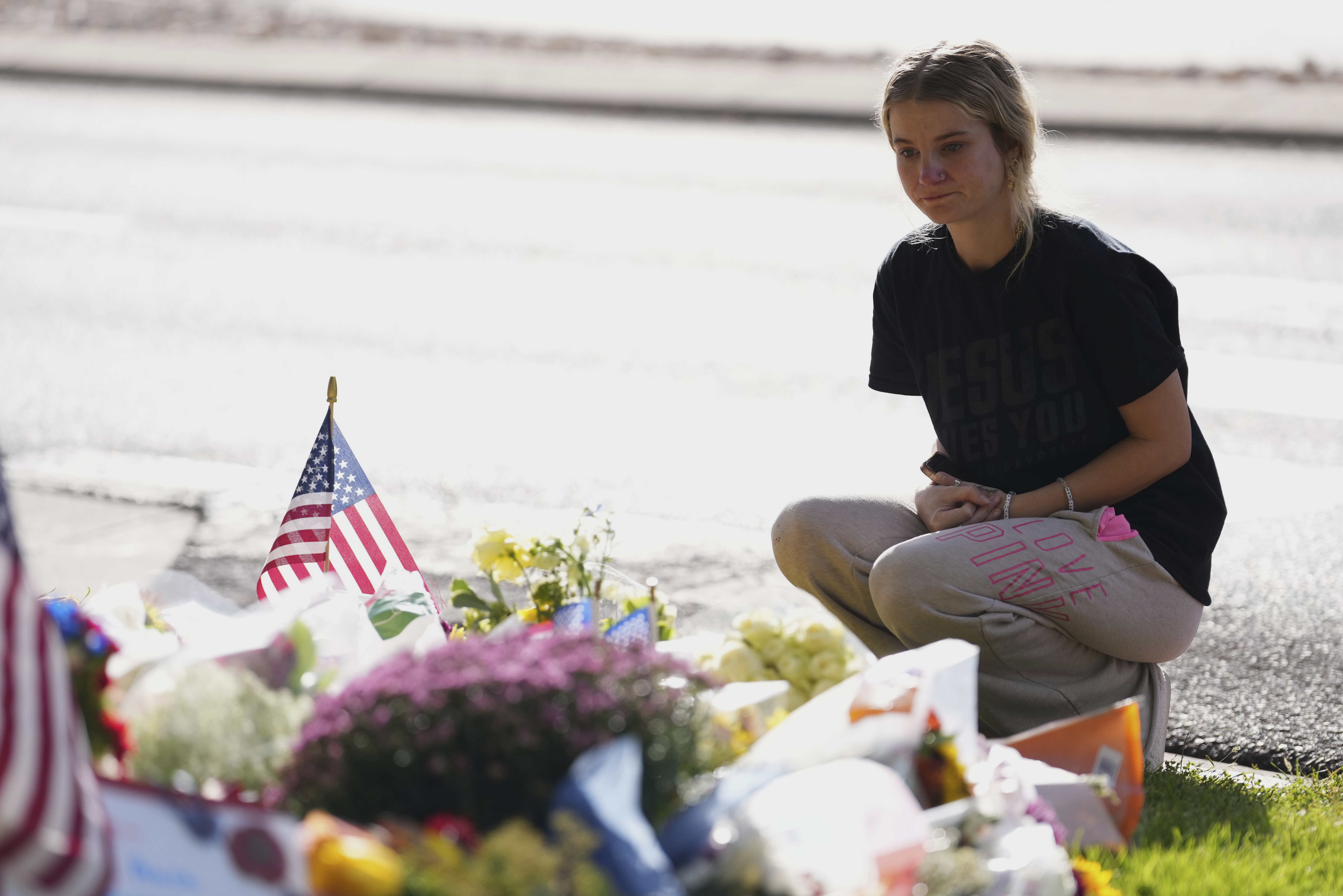 Meagan Bradley kneels at a memorial is set up for Charlie Kirk at Utah Valley University in Orem, Utah, Friday, Sept. 12, 2025. (Lindsey Wasson - AP)