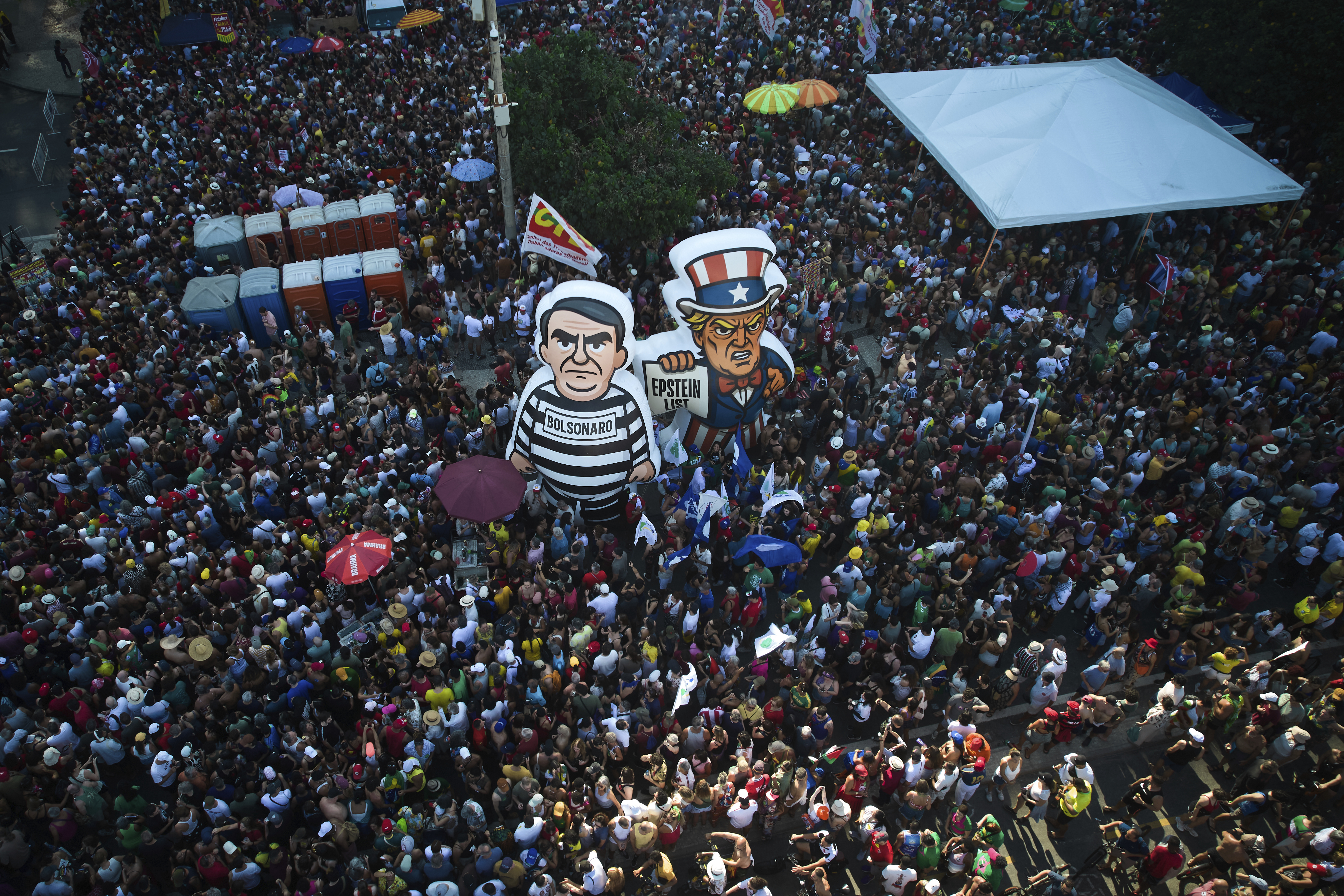 Demonstrators protest an amnesty bill that could benefit Brazilian former President Jair Bolsonaro and his allies convicted for a coup attempt, among floats of Bolsonaro and U.S. President Donald Trump at Copacabana beach, in Rio de Janeiro, Sunday, Sept. 21, 2025. (Silvia Izquierdo - AP)