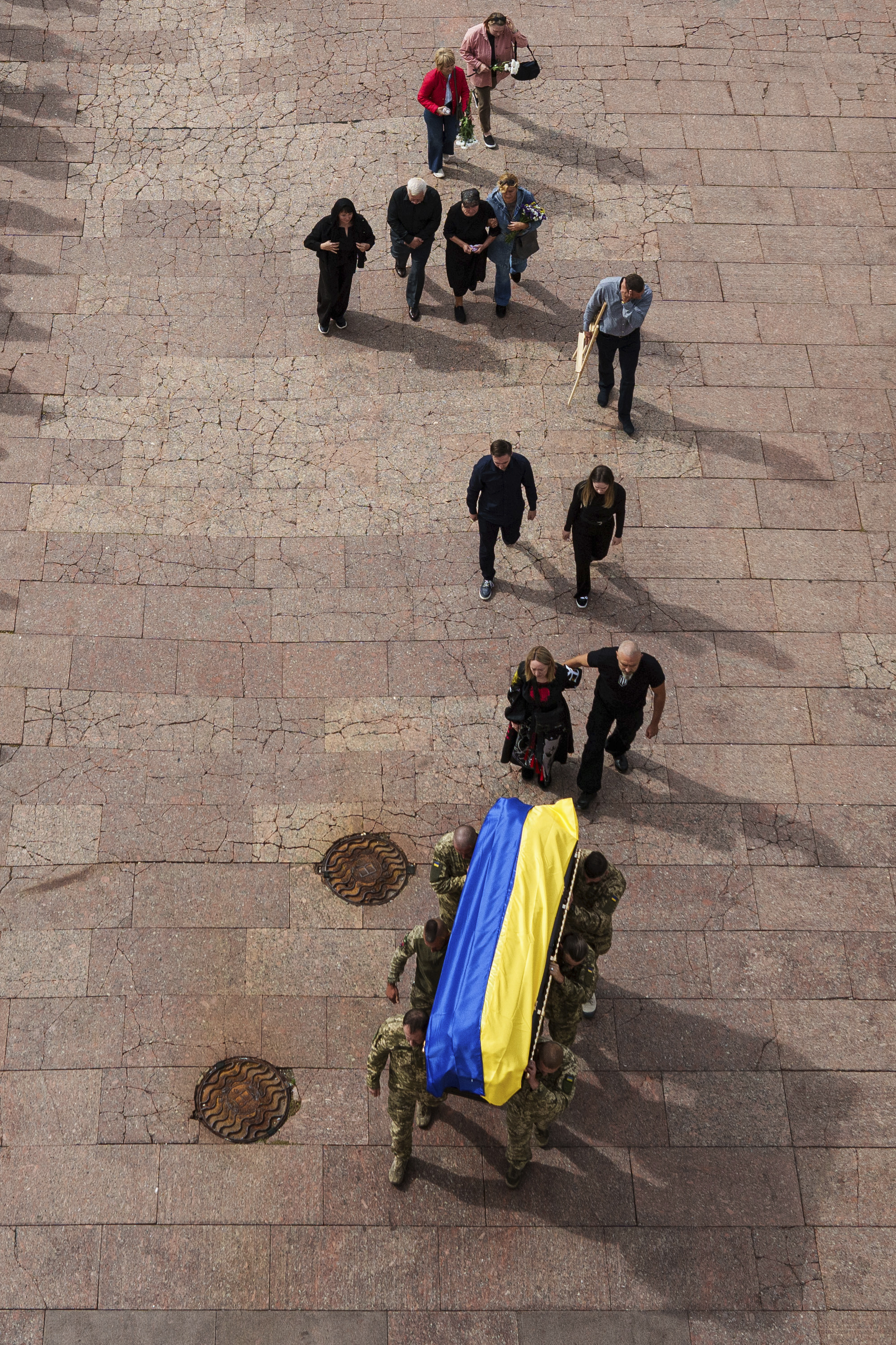 Honor guards carry the coffin of Artem Antonenko, a Ukrainian serviceman, during his funeral ceremony in the center of Kyiv, Ukraine, Friday, Sept. 19, 2025. (Evgeniy Maloletka - AP)