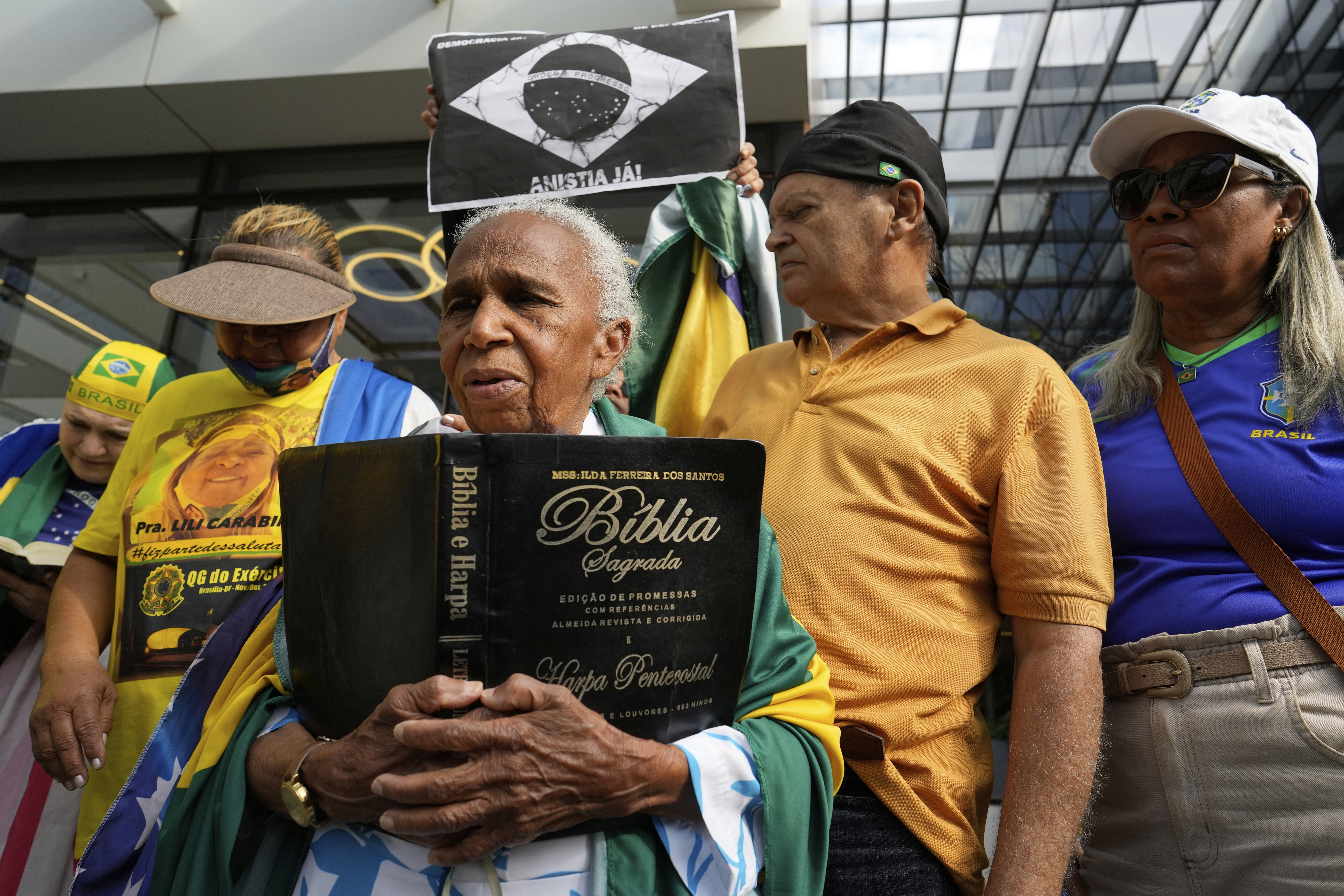 A supporter holding a Bible waits for the arrival of former President Jair Bolsonaro at a hospital, after he was temporarily allowed out of house arrest for medical treatment, in Brasilia, Brazil, Sunday, Sep. 14, 2025. (Eraldo Peres - AP)