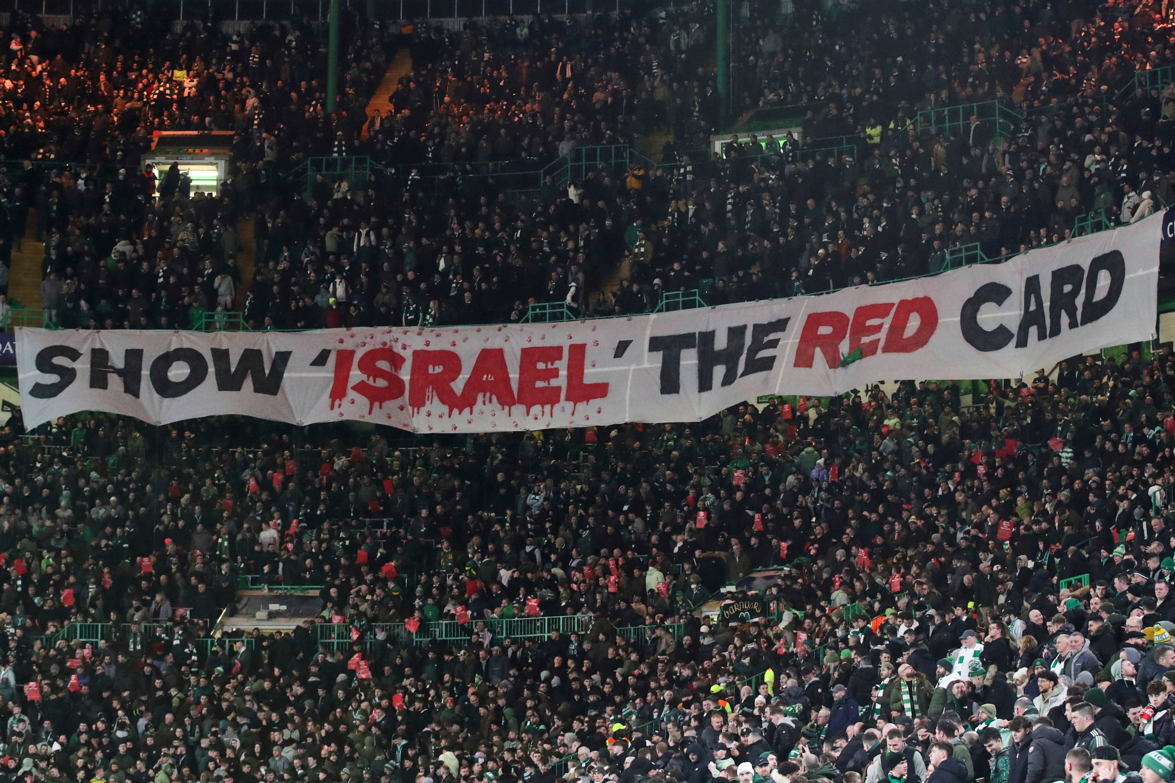 FILE - Celtic fans lift a protest banner about Israel during the Champions League playoff first leg soccer match between Glasgow Celtic and Bayern Munich at the Celtic Park Stadium in Glasgow, Scotland, Wednesday, Feb. 12, 2025. (Scott Heppell - AP)