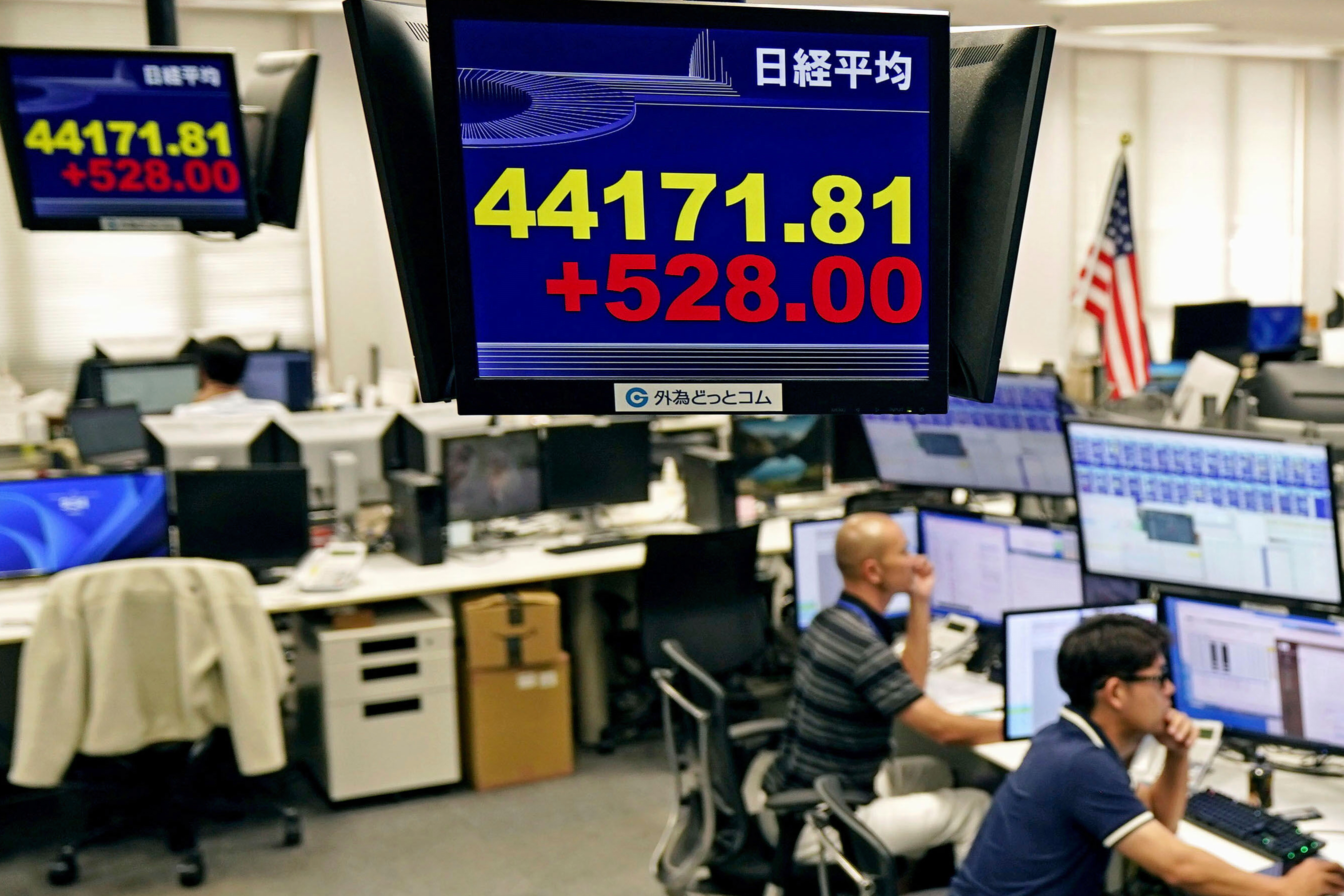 Employees of a foreign exchange dealing company sit under an electronic board showing the stock index of Japan's Nikkei 225, in Tokyo Tuesday, Sept. 9, 2025, in Tokyo. (Uncredited - Kyodo News)