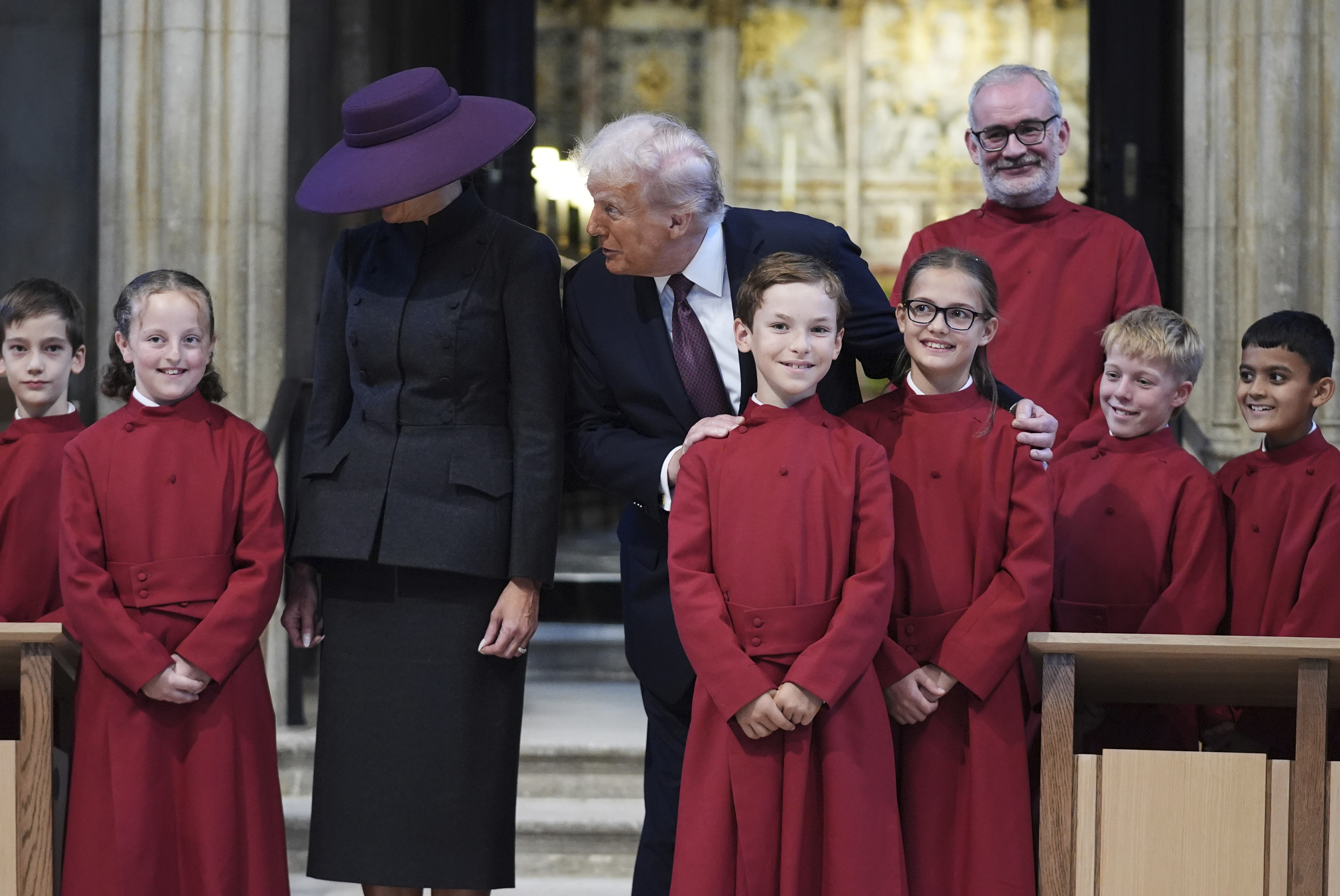 President Donald Trump and first lady Melania Trump pose with a childrens choir as they receive a tour of St. George's Chapel at Windsor Castle, Windsor, England, Wednesday, Sept. 17, 2025. (Evan Vucci - Pool AP)