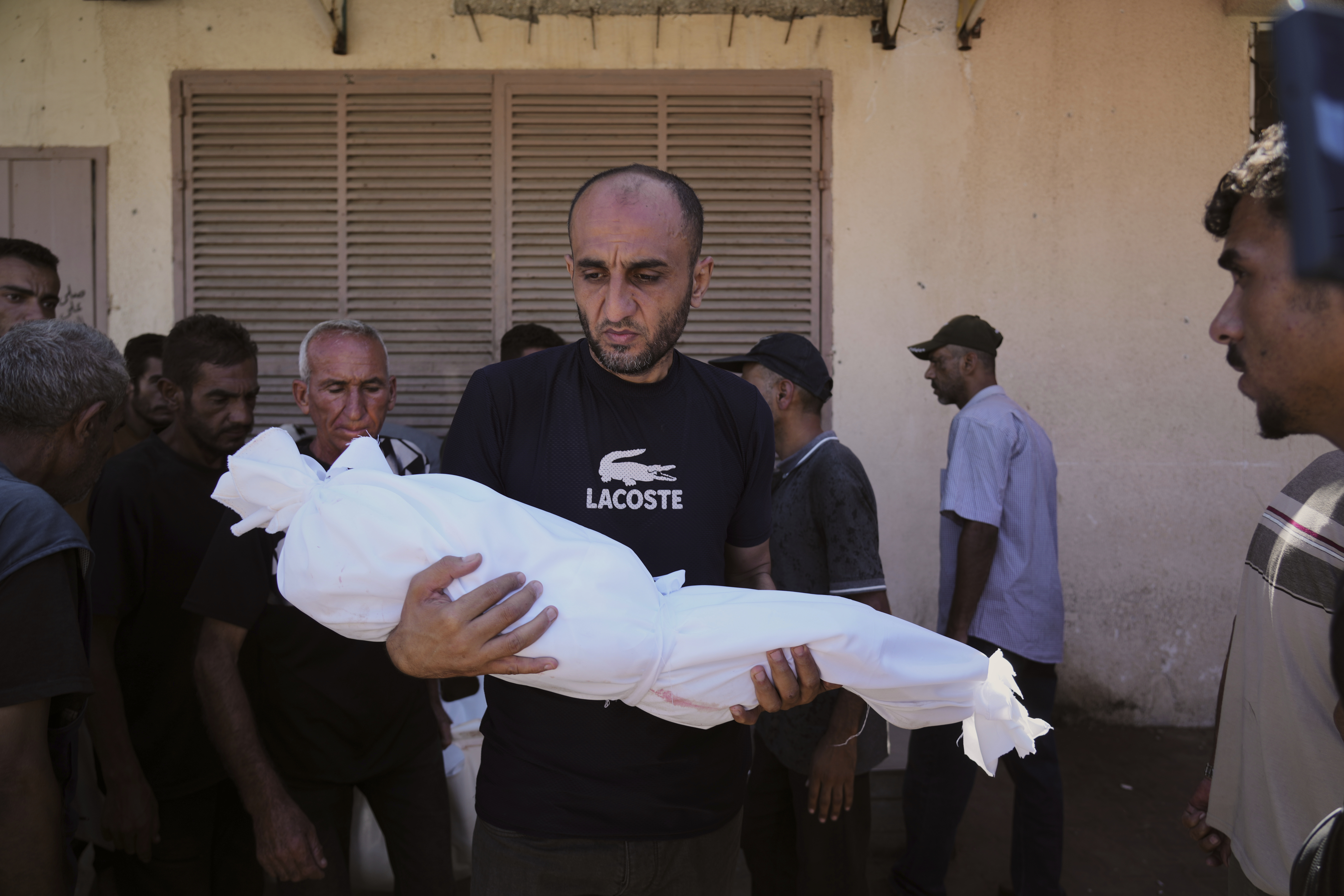 A man carries the body of 3-year-old Palestinian child Nour Abu Ouda, killed in an Israeli airstrike on the Gaza Strip, at Al-Aqsa Hospital in Deir al-Balah, Sunday, Sept. 14, 2025. (Abdel Kareem Hana - AP)