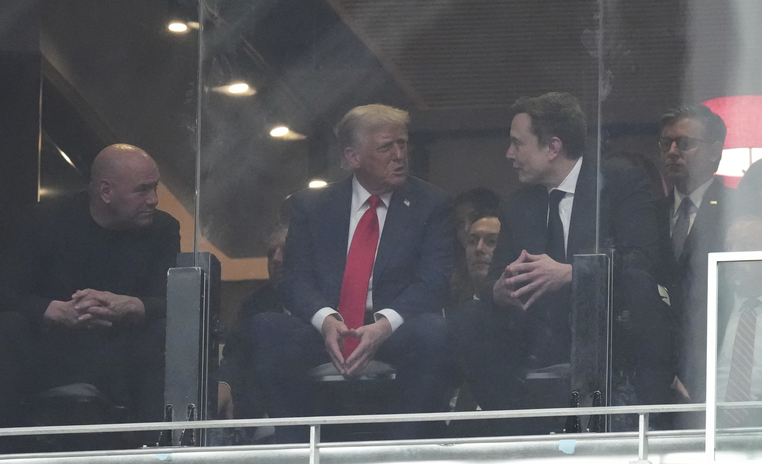 From left, Dana White, President Donald Trump, Elon Musk and House Speaker Mike Johnson, R-La., talk at a memorial for Charlie Kirk, Sunday, Sept. 21, 2025, at State Farm Stadium in Glendale, Ariz. (Ross D. Franklin - AP)