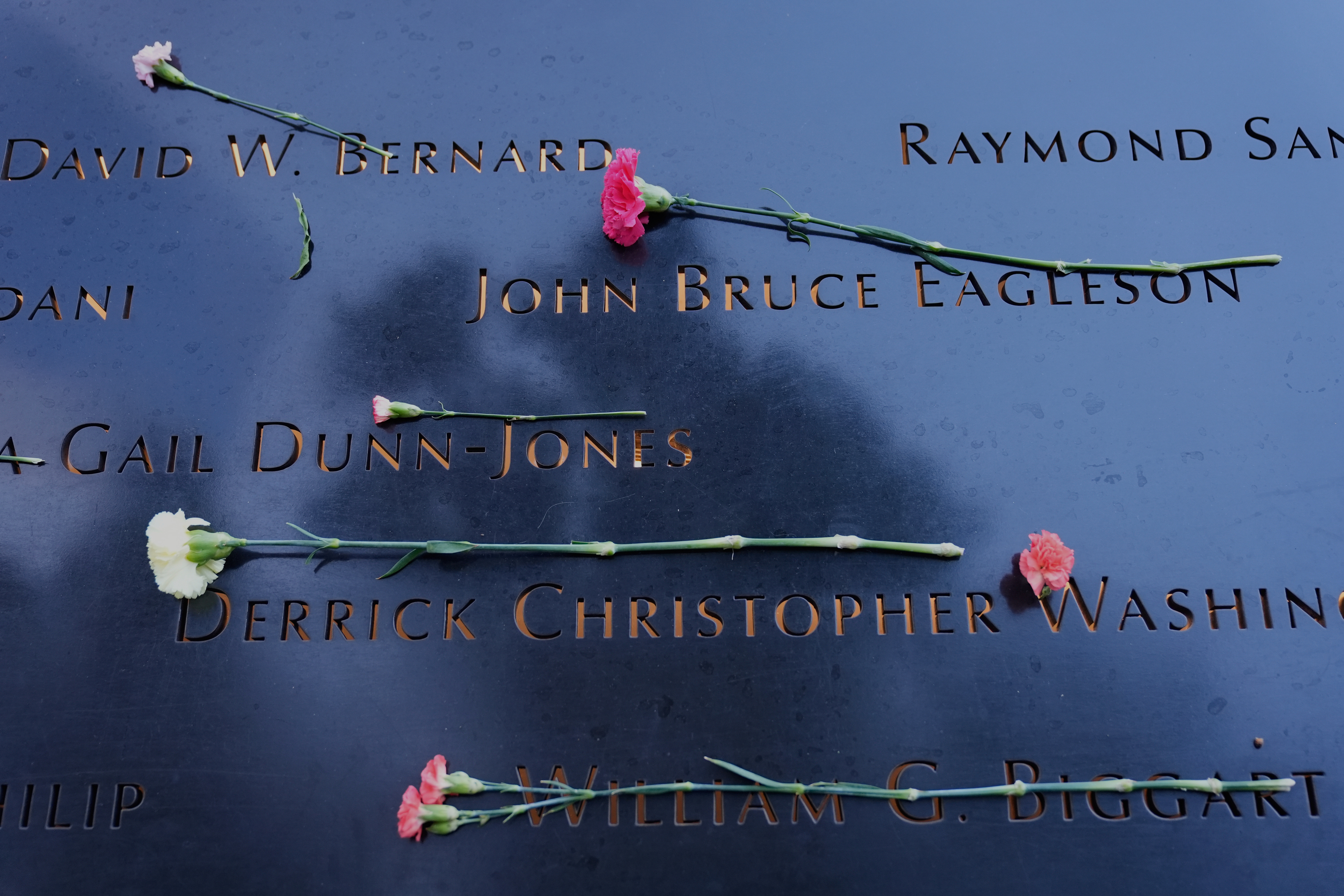 Flowers lay on names inscribed at the 9/11 Memorial before the start of a ceremony commemorating the 24th anniversary of the Sept. 11, 2001, attacks, Thursday, Sept. 11, 2025, in New York. (Seth Wenig - AP)