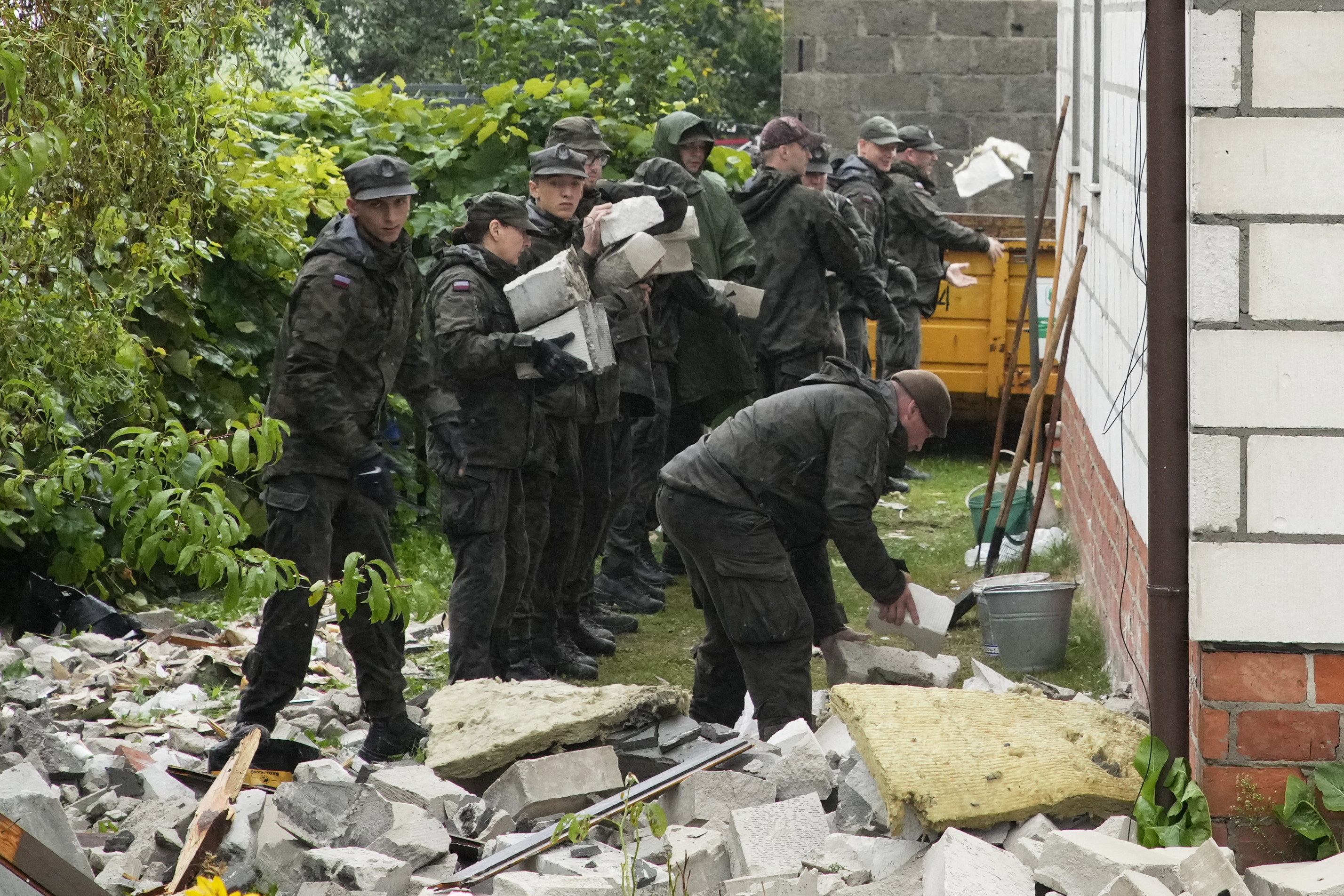 Territorial defense officers clean up debris from the destroyed roof of a house, after multiple Russian drones struck, in Wyryki near Lublin, Poland, Thursday, Sept. 11, 2025. (Czarek Sokolowski - AP)