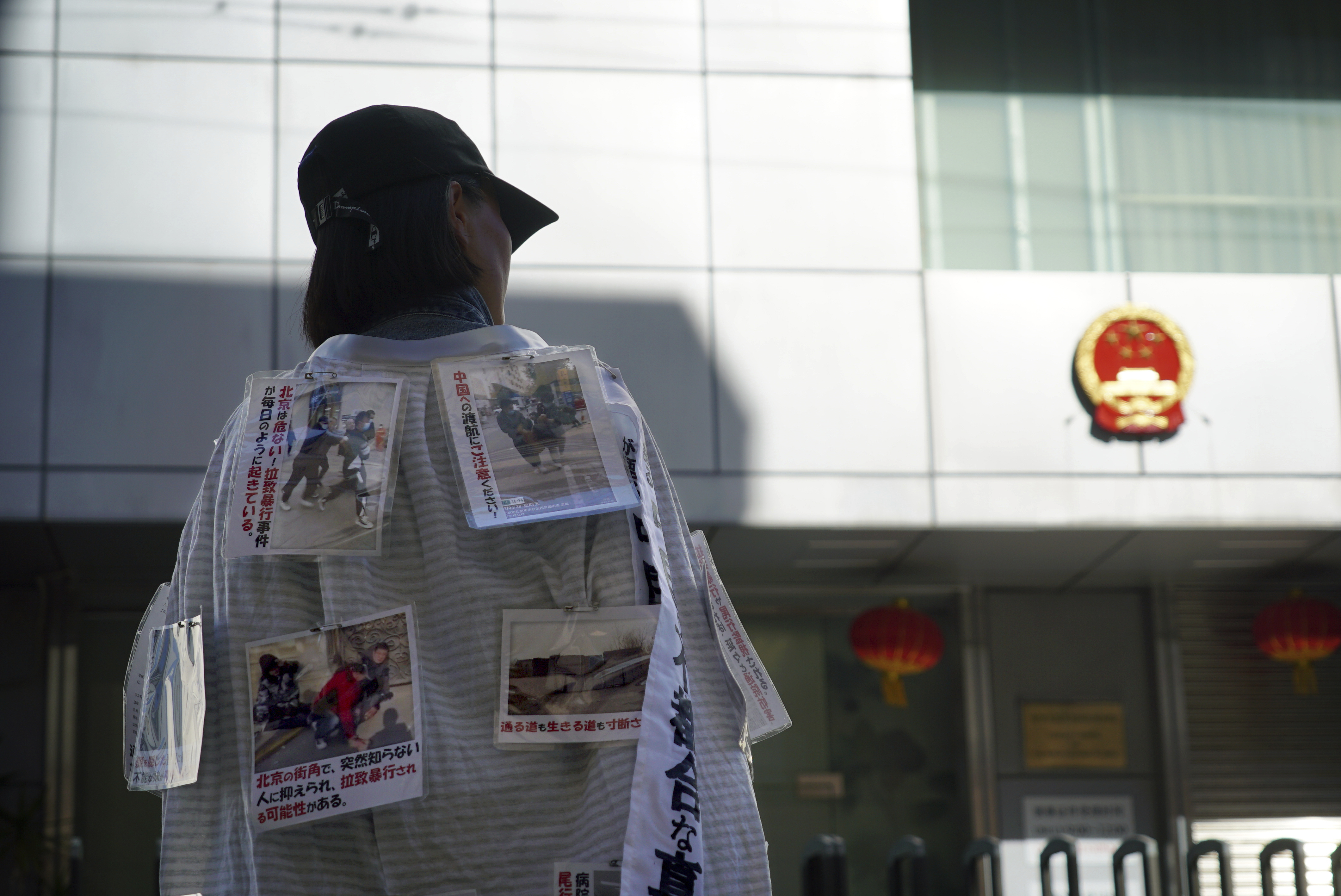 Yang Caiying, who is living in exile in Japan, wears signs protesting state repression of her family outside the Chinese consulate in Nagoya, Japan, Friday, May 17, 2024. (Dake Kang - AP)
