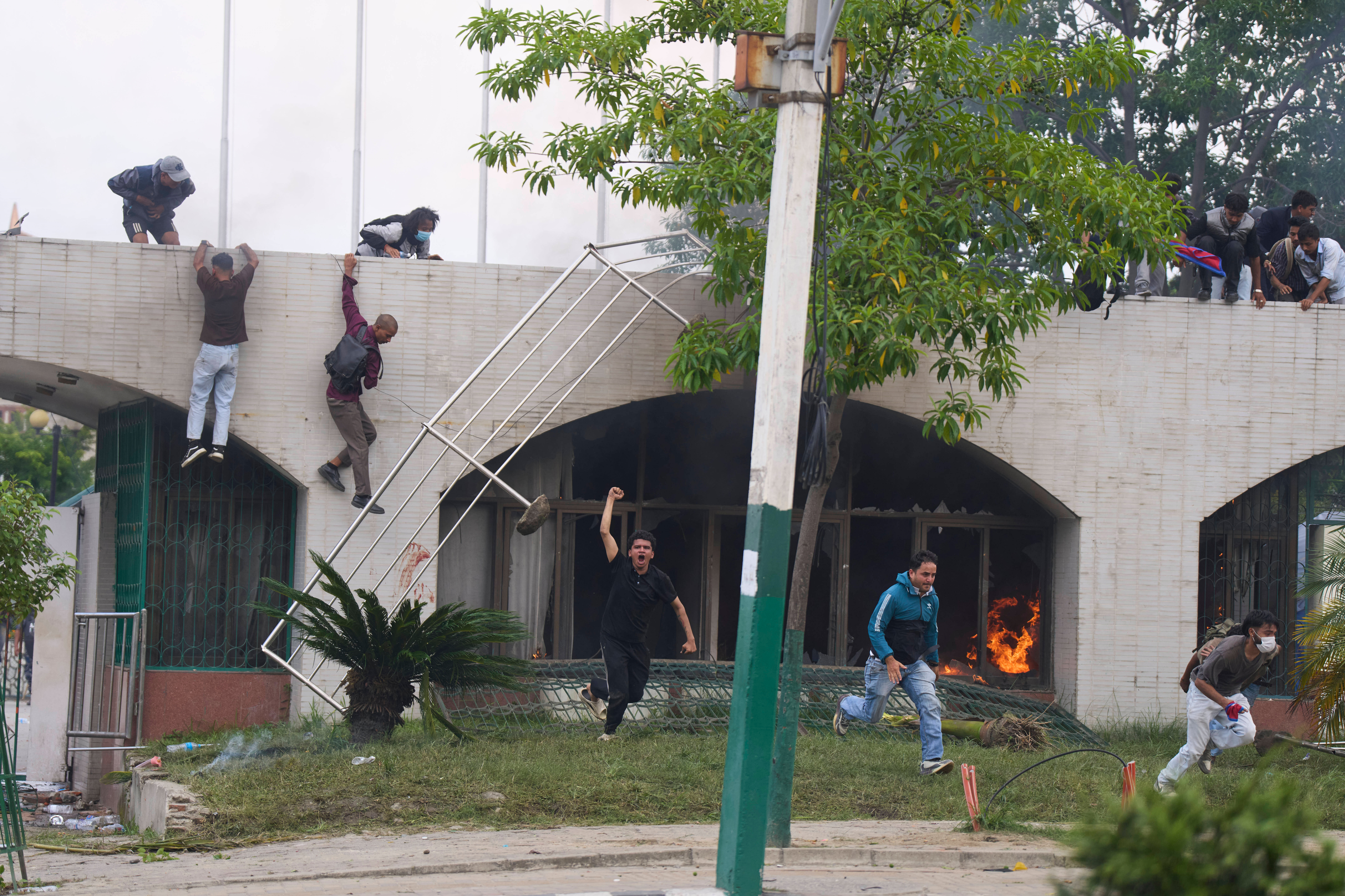 Protesters jump from a burning building during clashes with riot police in Kathmandu, Nepal, Monday, Sept. 8, 2025. (Niranjan Shrestha - AP)