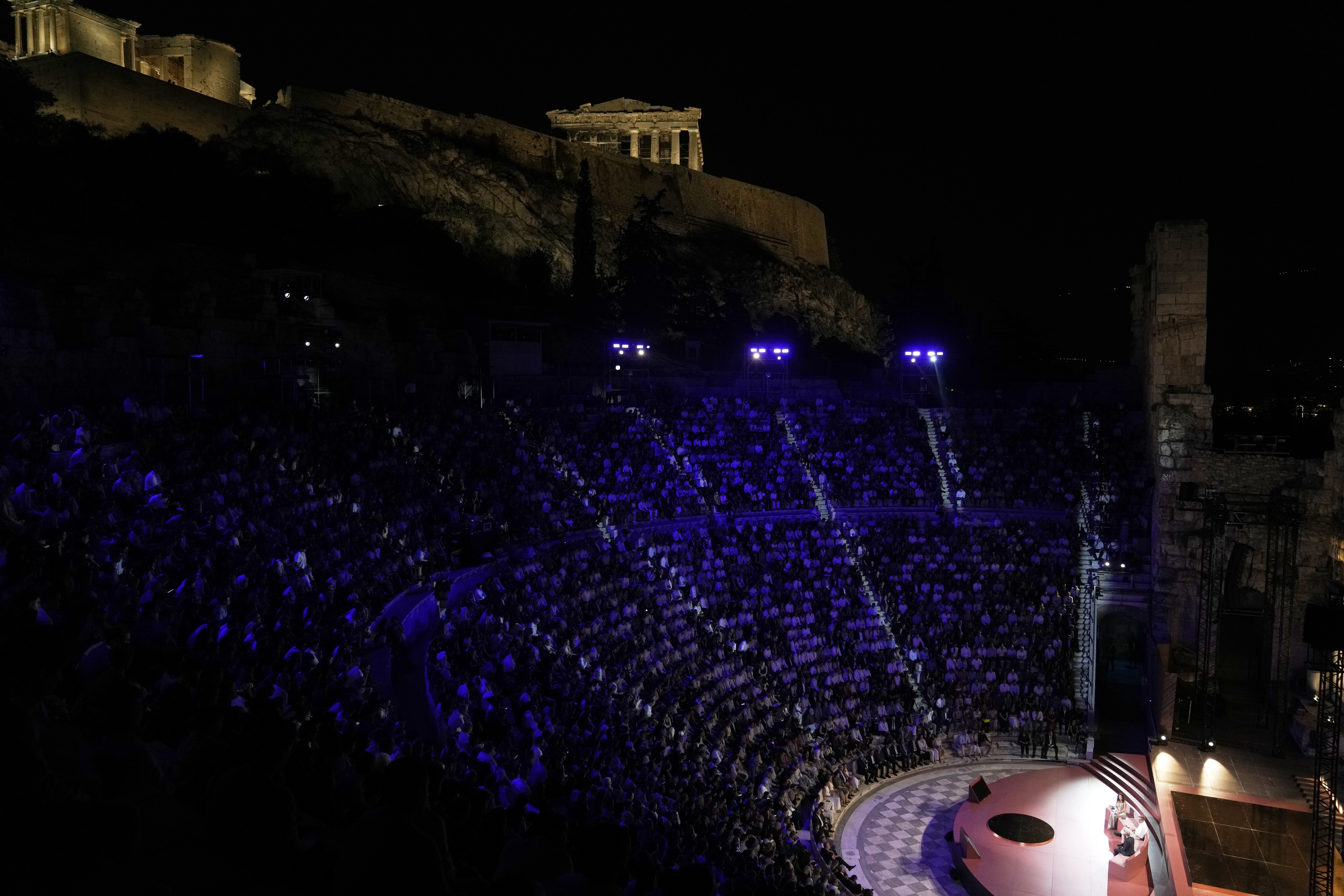Demis Hassabis, CEO of Google's artificial intelligence research company DeepMind, bottom right, and Greece's Prime Minister Kyriakos Mitsotakis, bottom center, discuss the future of AI, ethics and democracy during an event at the Odeon of Herodes Atticus, under Acropolis ancient hill, in Athens, Greece, Friday, Sept. 12, 2025. (Thanassis Stavrakis - AP)