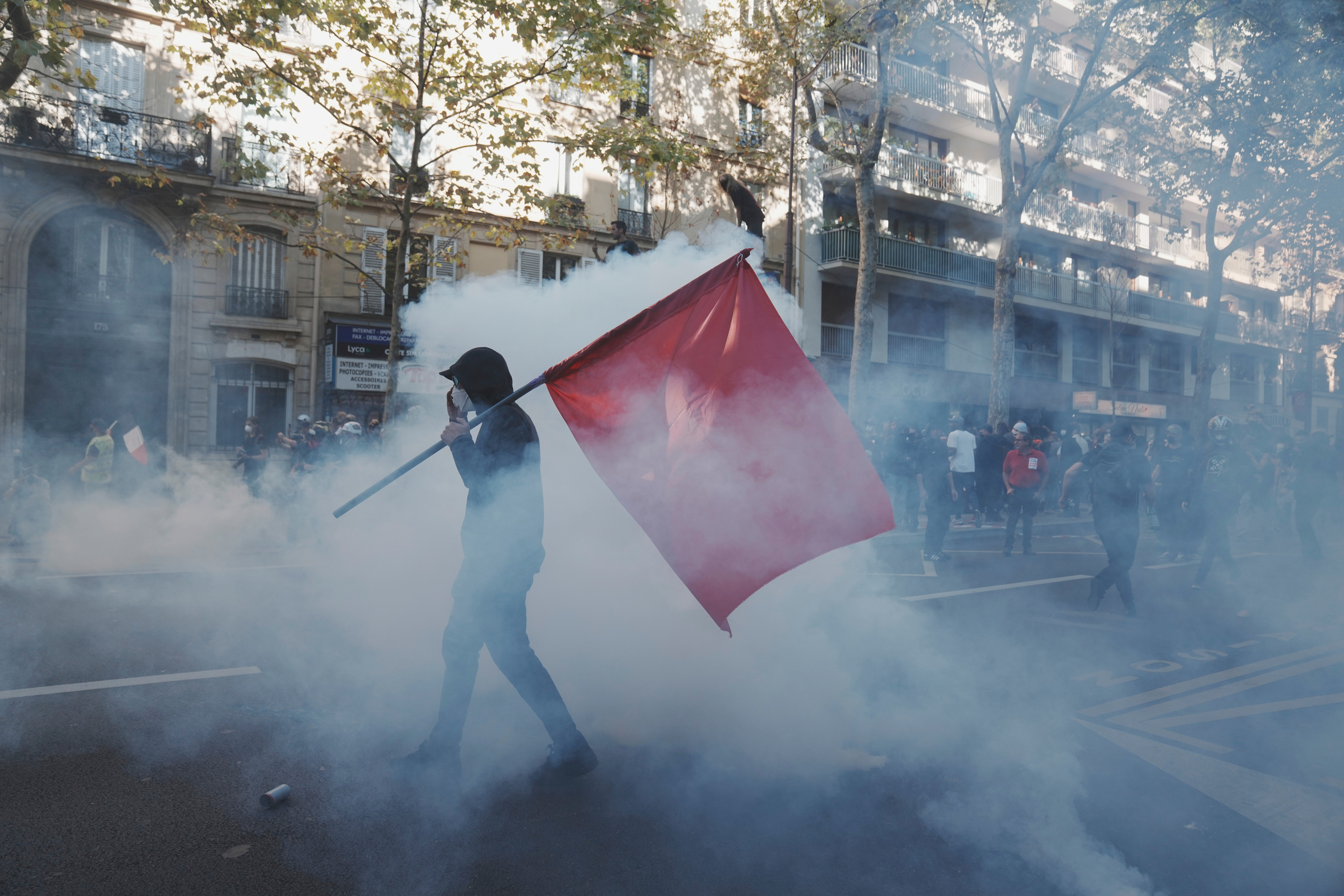 Protesters march in the teargas during a demonstration called by major trade unions to oppose budget cuts, in Paris, France, Thursday, Sept. 18, 2025. (Thibault Camus - AP)