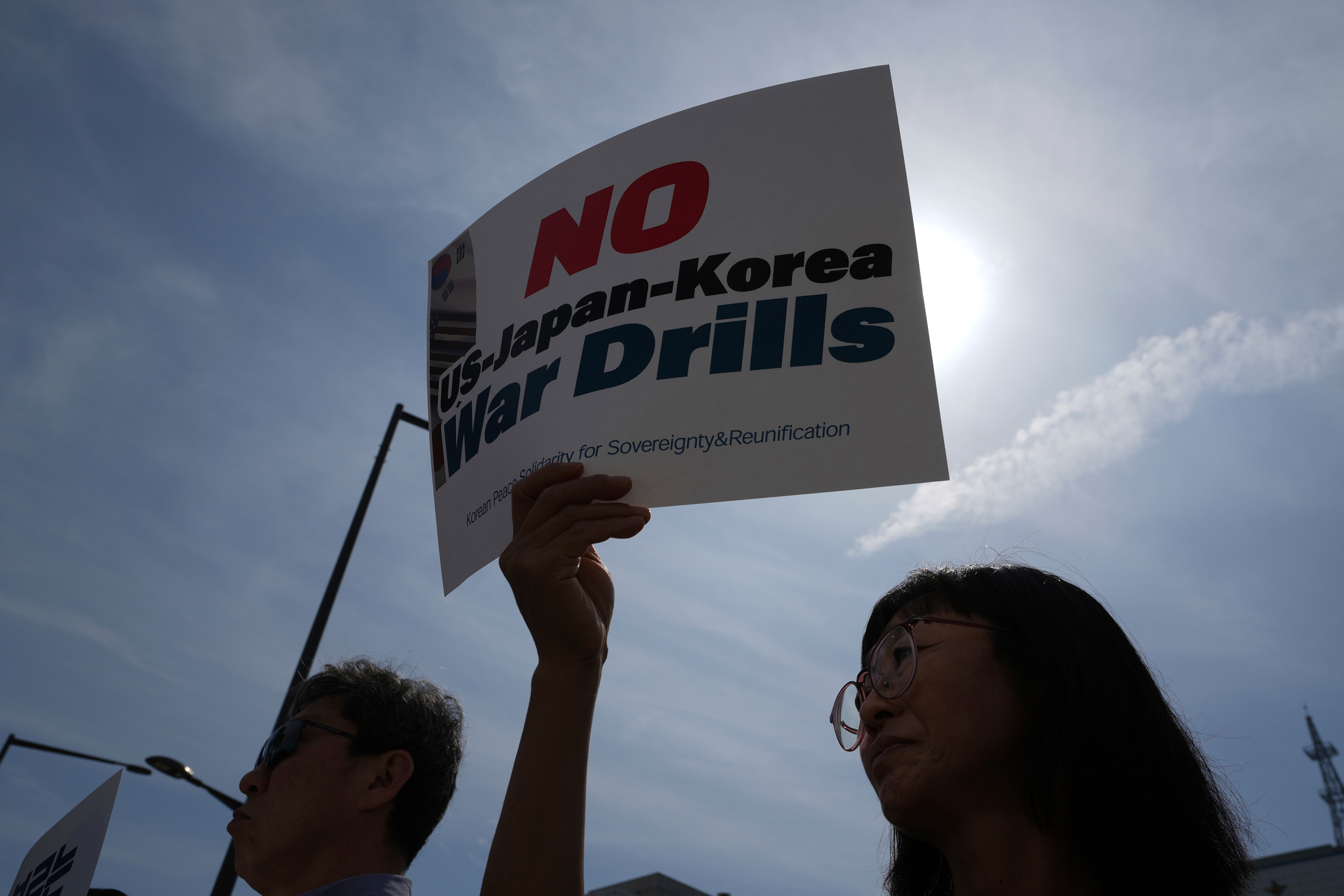 A protester holds a sign during a press conference to oppose the military exercise called Freedom Edge in Seoul, South Korea, Monday, Sept. 15, 2025. (Lee Jin-man - AP)