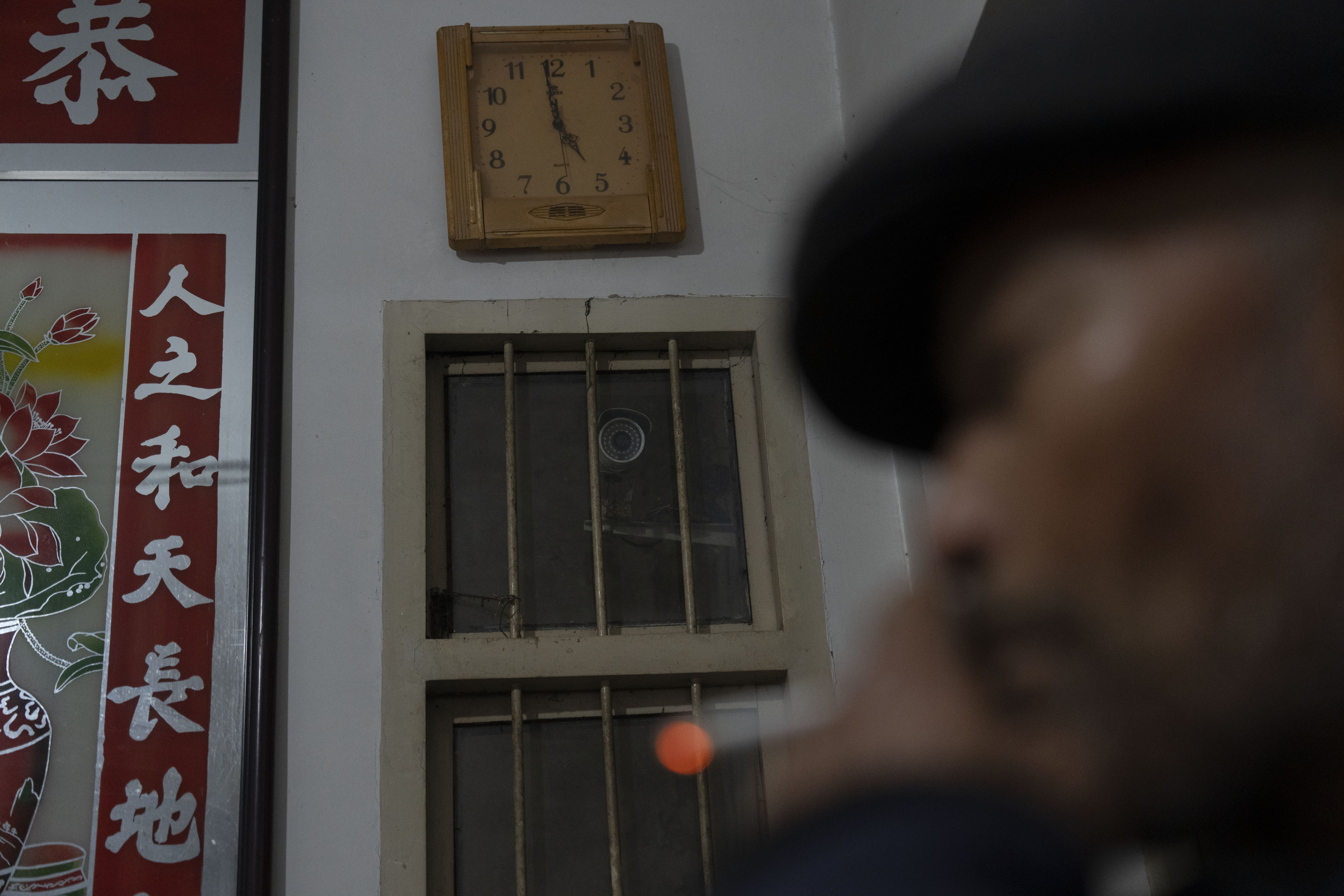 Petitioner Yang Guoliang smokes near a security camera his family installed inside their home in Changzhou in eastern China's Jiangsu Province, Friday, Dec. 13, 2024. (Ng Han Guan - AP)