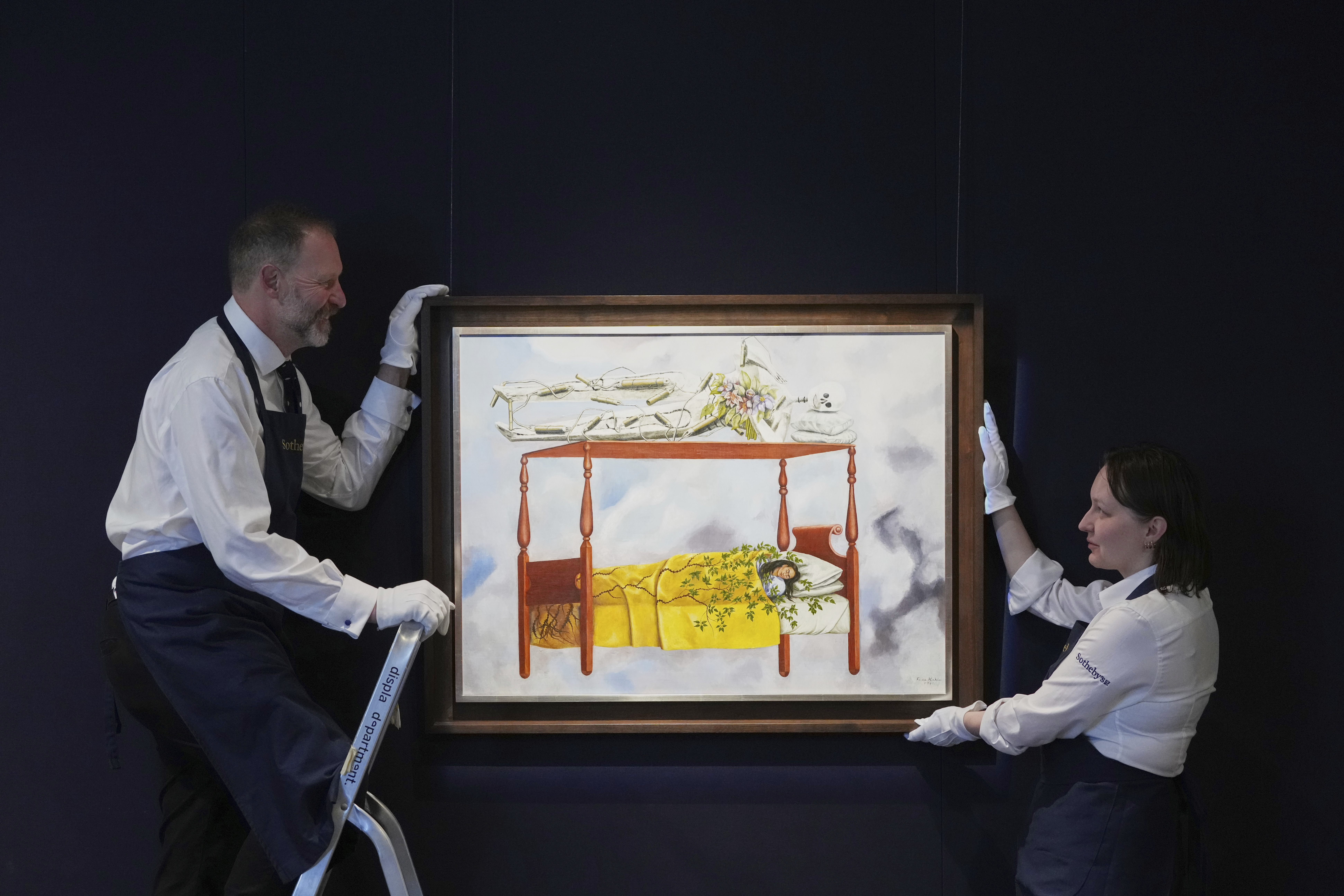 A painting by Frida Kahlo called El sueño (La cama) is displayed at Sotheby's auction rooms, the painting estimated at 40-60 million US dollars is part of a collection of surrealist masterpieces unveiled in London ahead of their sale in New York, Friday, Sept. 19, 2025. (Kirsty Wigglesworth - AP)