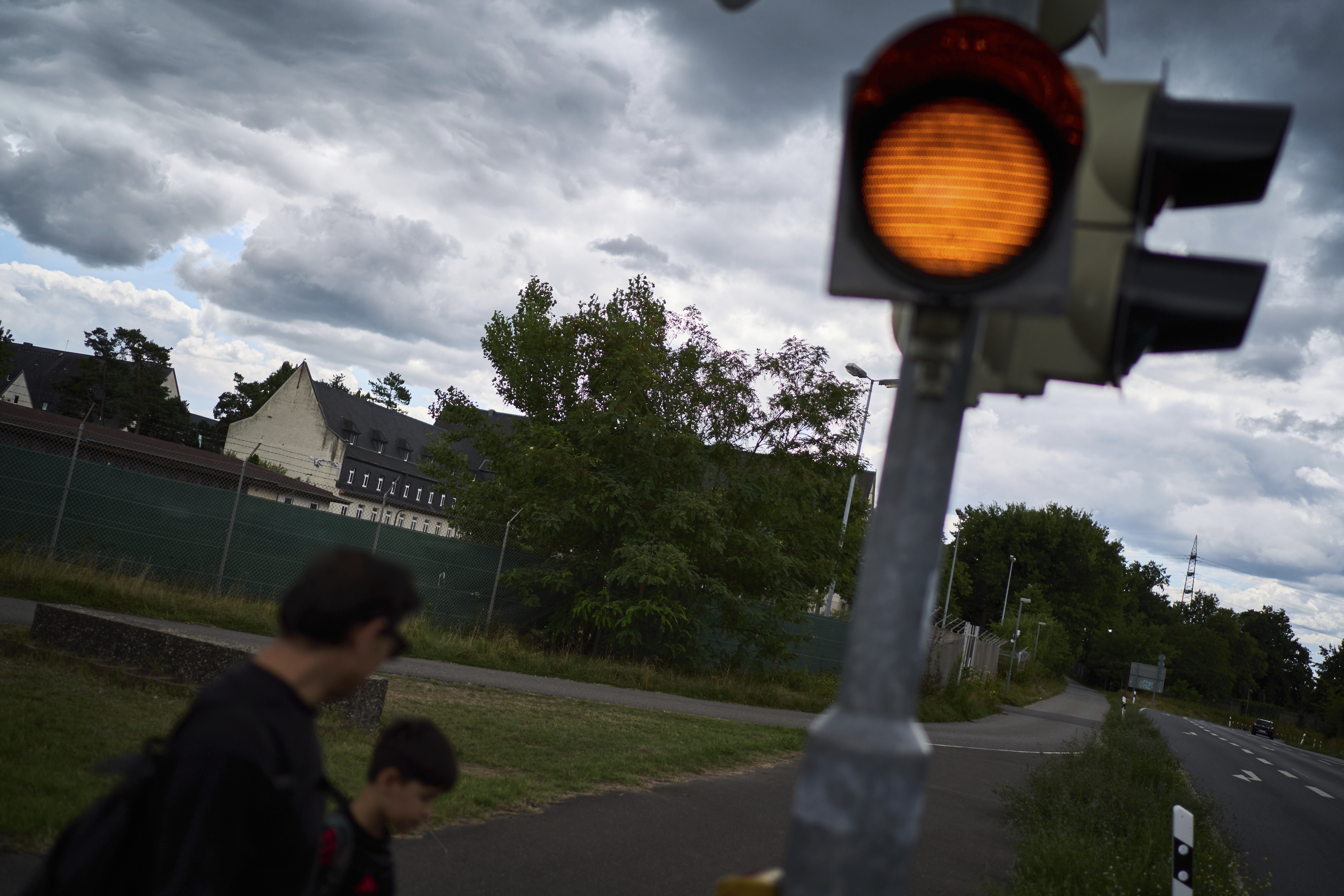 Former Xinjiang government engineer Nureli Abliz, and his son, Ilyon, 9, leave their refugee camp at the Tompkins Barracks, a former U.S. Army installation, in Schwetzingen, Germany, Wednesday, July 23, 2025. (David Goldman - AP)