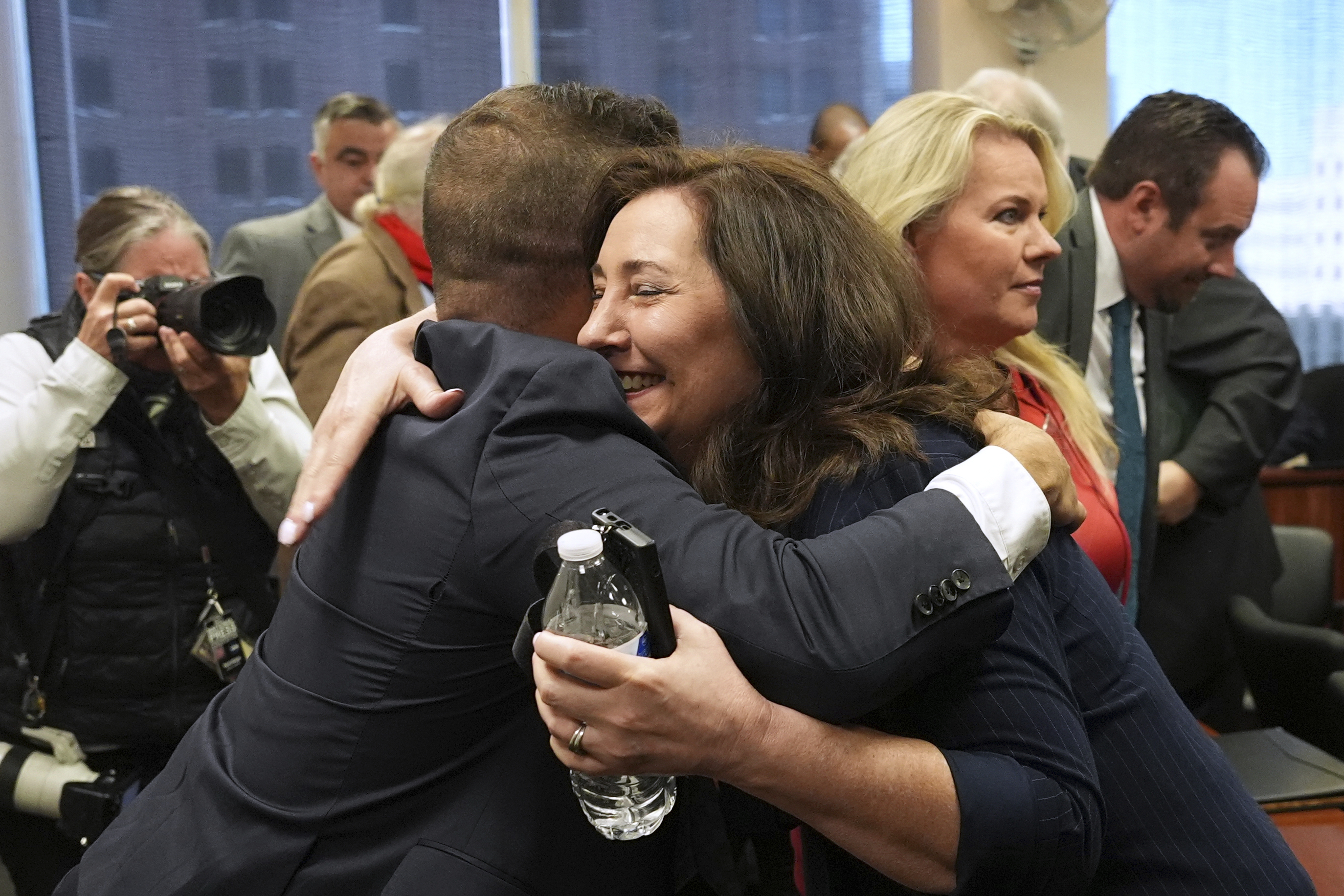 Amy Facchinello hugs an attorney after a Michigan judge dismissed the criminal cases against 15 people accused of acting falsely as electors for President Donald Trump in the 2020 election Tuesday, Sept. 9, 2025 in Lansing, Mich. (Paul Sancya - AP)