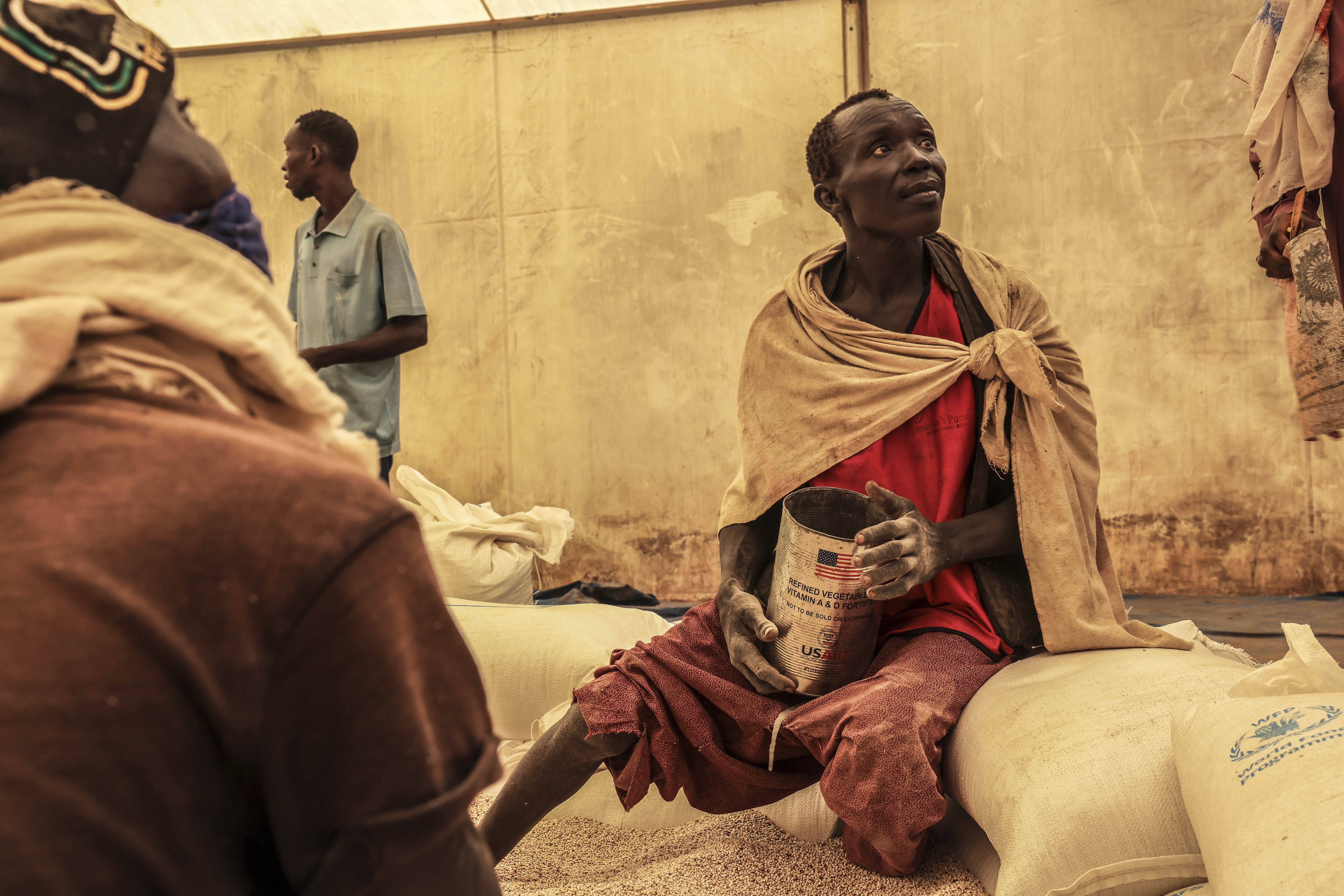 A man scoops up portions of wheat to be allocated to each waiting family after distribution by the U.N. World Food Programme (WFP) in the Gendrassa Refugee Camp, Maban, South Sudan, Wednesday, Aug. 20, 2025. (Caitlin Kelly - AP)