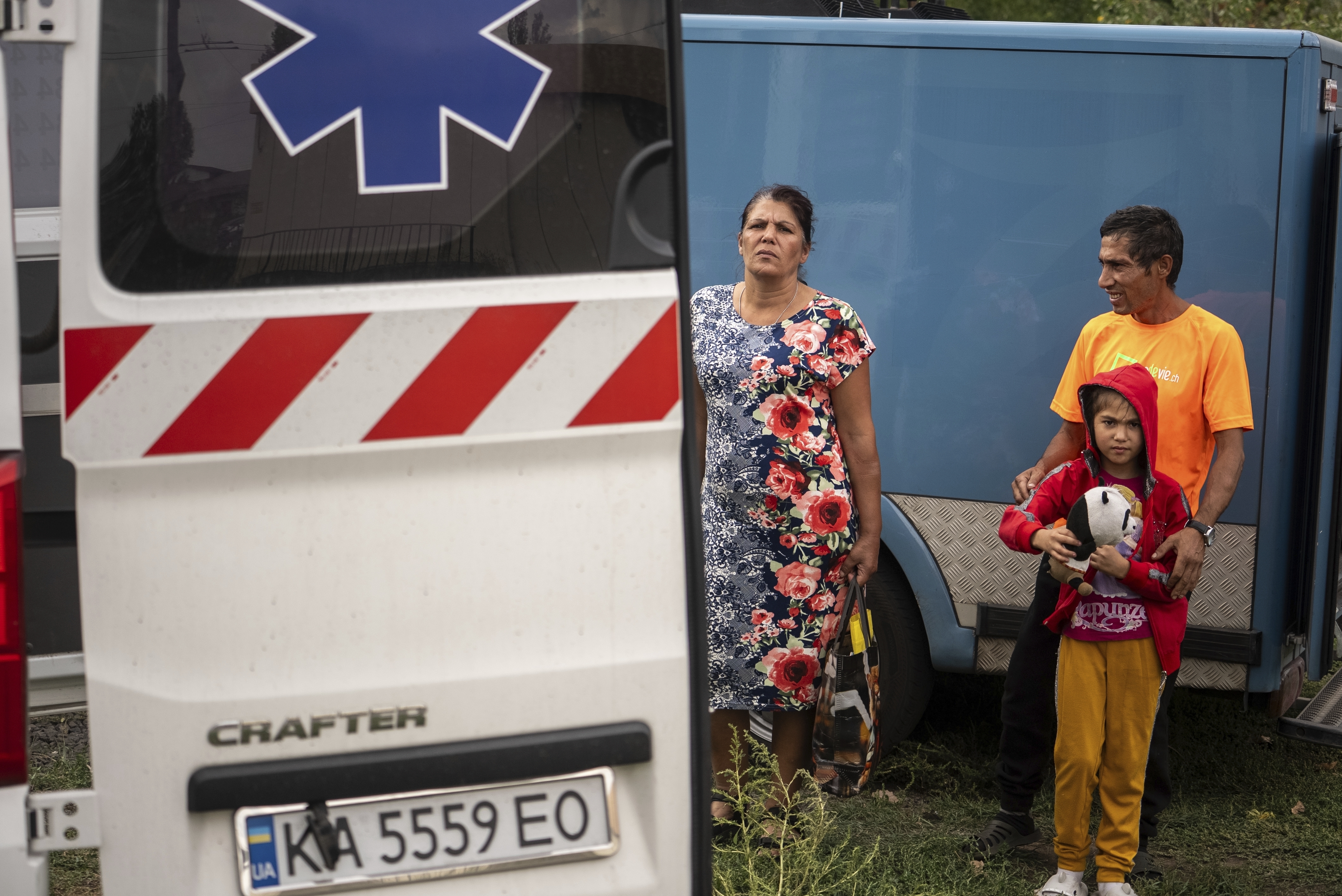 A family stays near an ambulance during the evacuation from the village of Yarova, that was hit by Russian aerial strike, which killed dozens of civilians, in Sloviansk, Donetsk region, Tuesday, Sept.9, 2025. (Alex Babenko - AP)