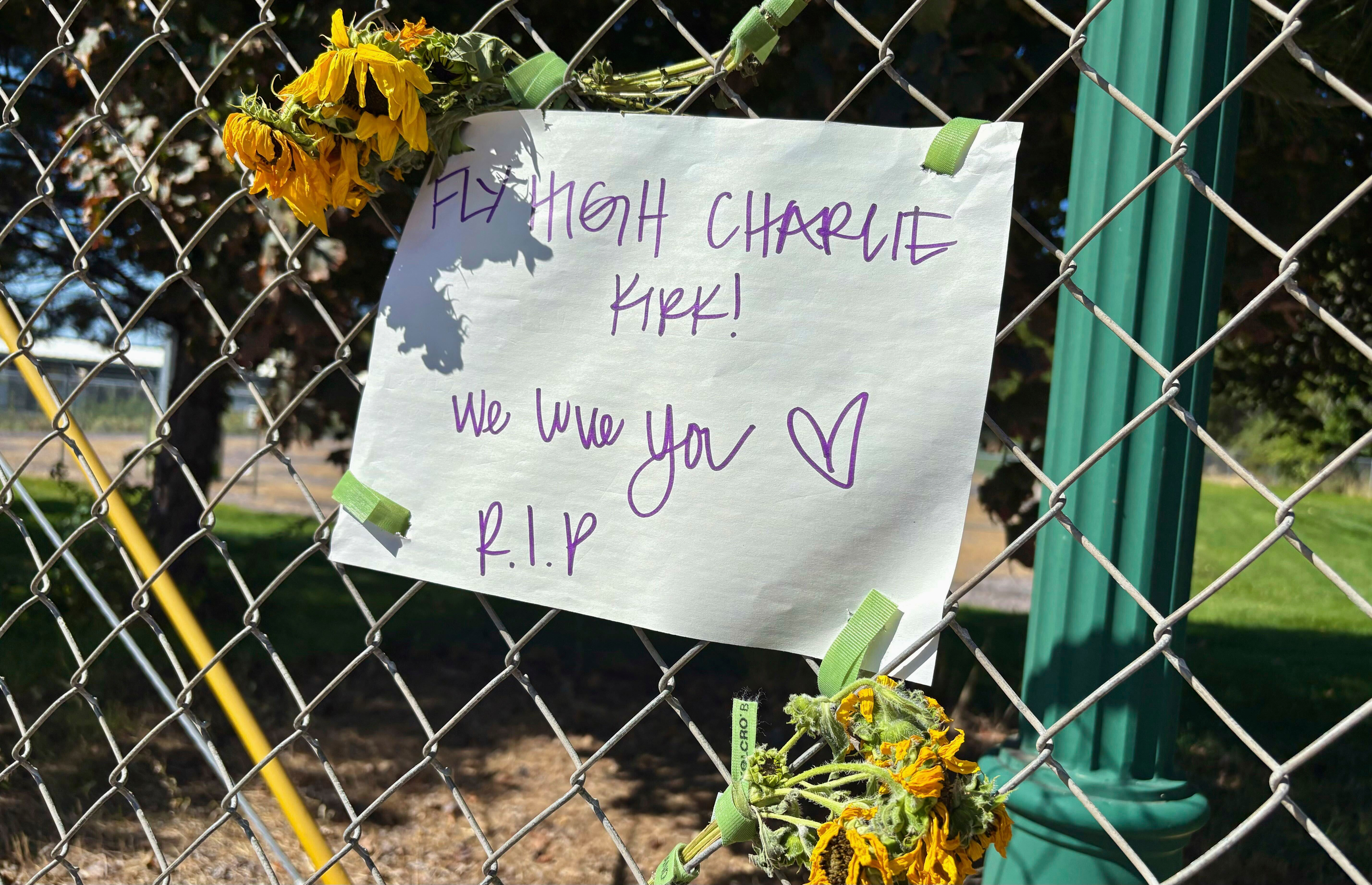 A sign reading “Fly High Charlie Kirk! We love you. R.I.P.” is seen hanging on a fence with flowers across the street from the Utah Valley University campus, in Orem, Utah, Thursday, Sept. 11, 2025. (Hannah Schoenbaum - AP)