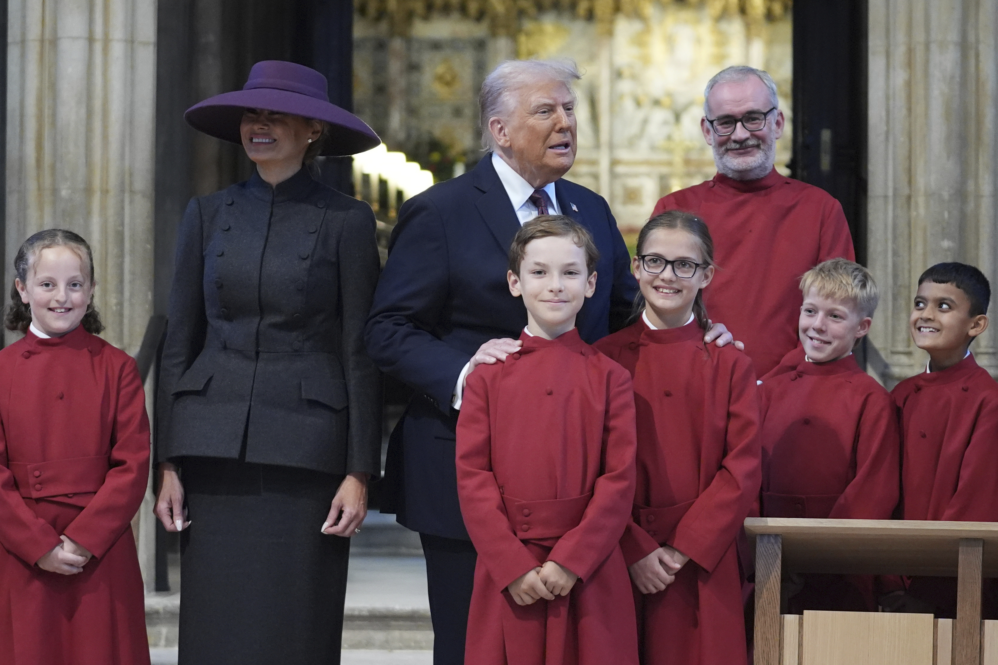 President Donald Trump and first lady Melania Trump pose with a childrens choir as they receive a tour of St. George's Chapel at Windsor Castle, Windsor, England, Wednesday, Sept. 17, 2025. (Evan Vucci - Pool AP)