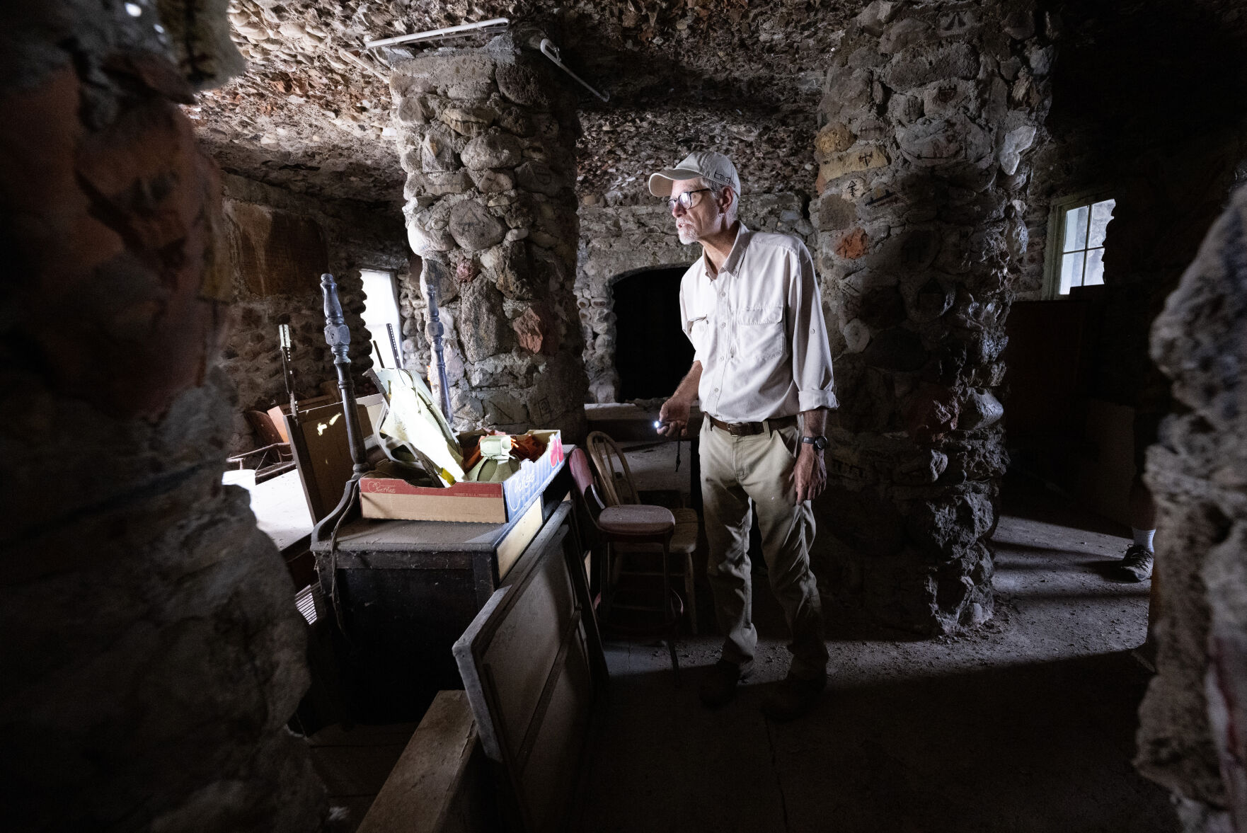 Reed Weimer shines a light on the Indian Cafe inside the World’s Wonder Tower in August outside Genoa. The cafe fed travelers at the roadside attraction in the early days through the 1930s. (photos by Christian Murdock, The Gazette)