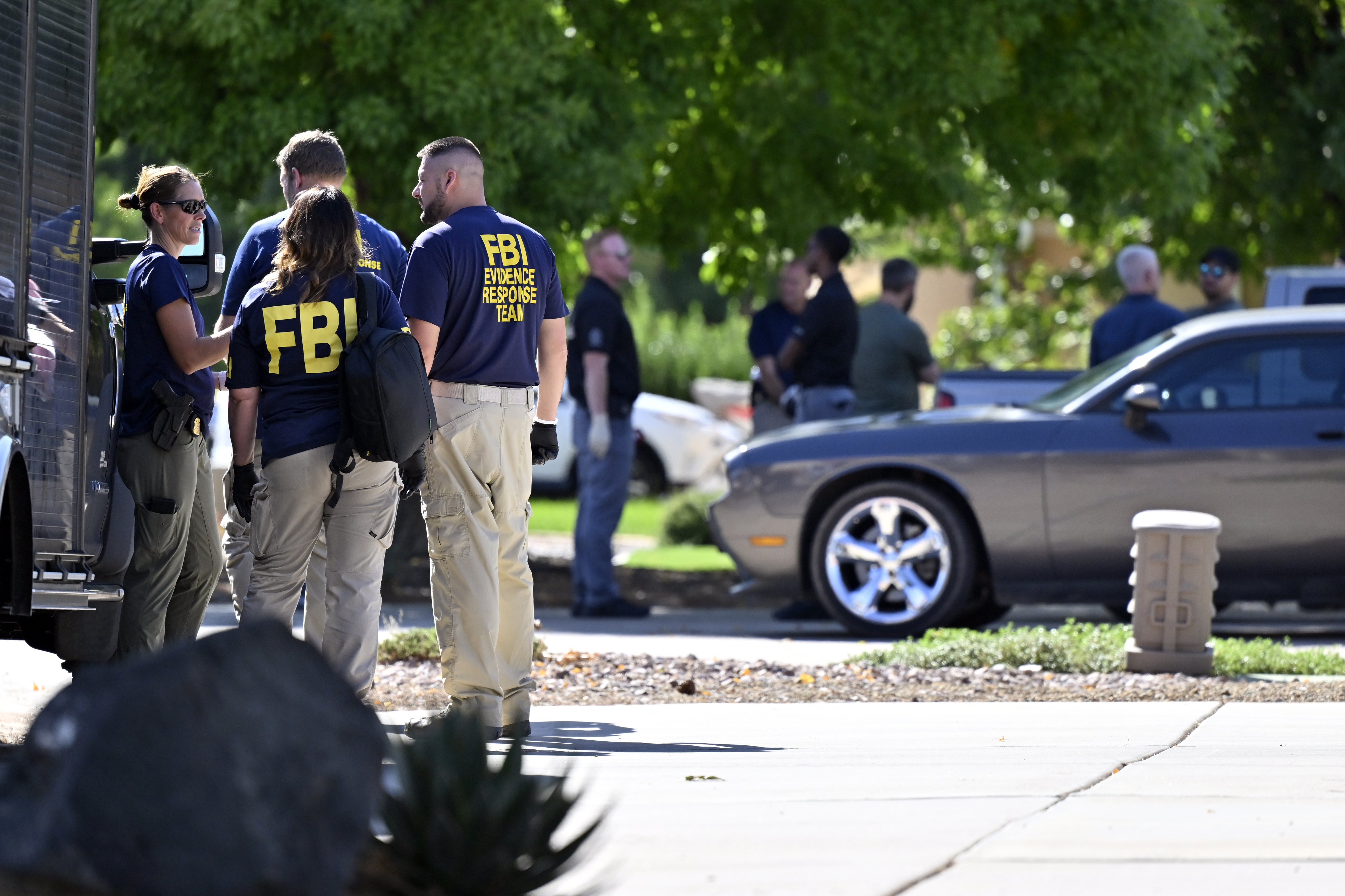 Federal law enforcement officials stand outside the family home of Tyler Robinson, the man accused of killing Turning Point USA CEO and co-founder Charlie Kirk, Friday, Sept. 12, 2025, in Washington, Utah. (David Becker - FR170737 AP)