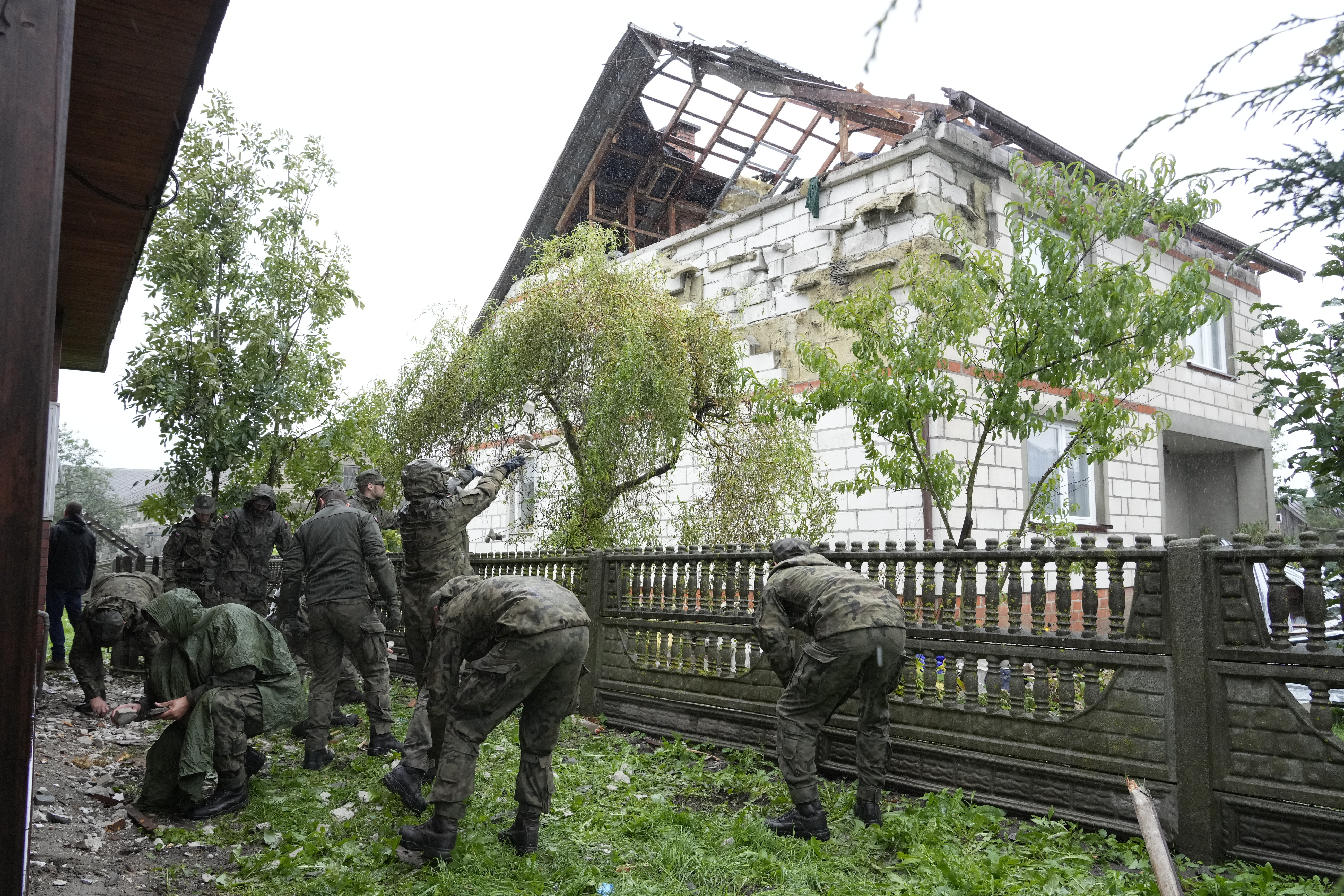 Territorial defense officers clean up debris from the destroyed roof of a house, after Russian drones violated Polish airspace during an attack on Ukraine, in Wyryki near Lublin, Poland, Thursday, Sept. 11, 2025. (Czarek Sokolowski - AP)