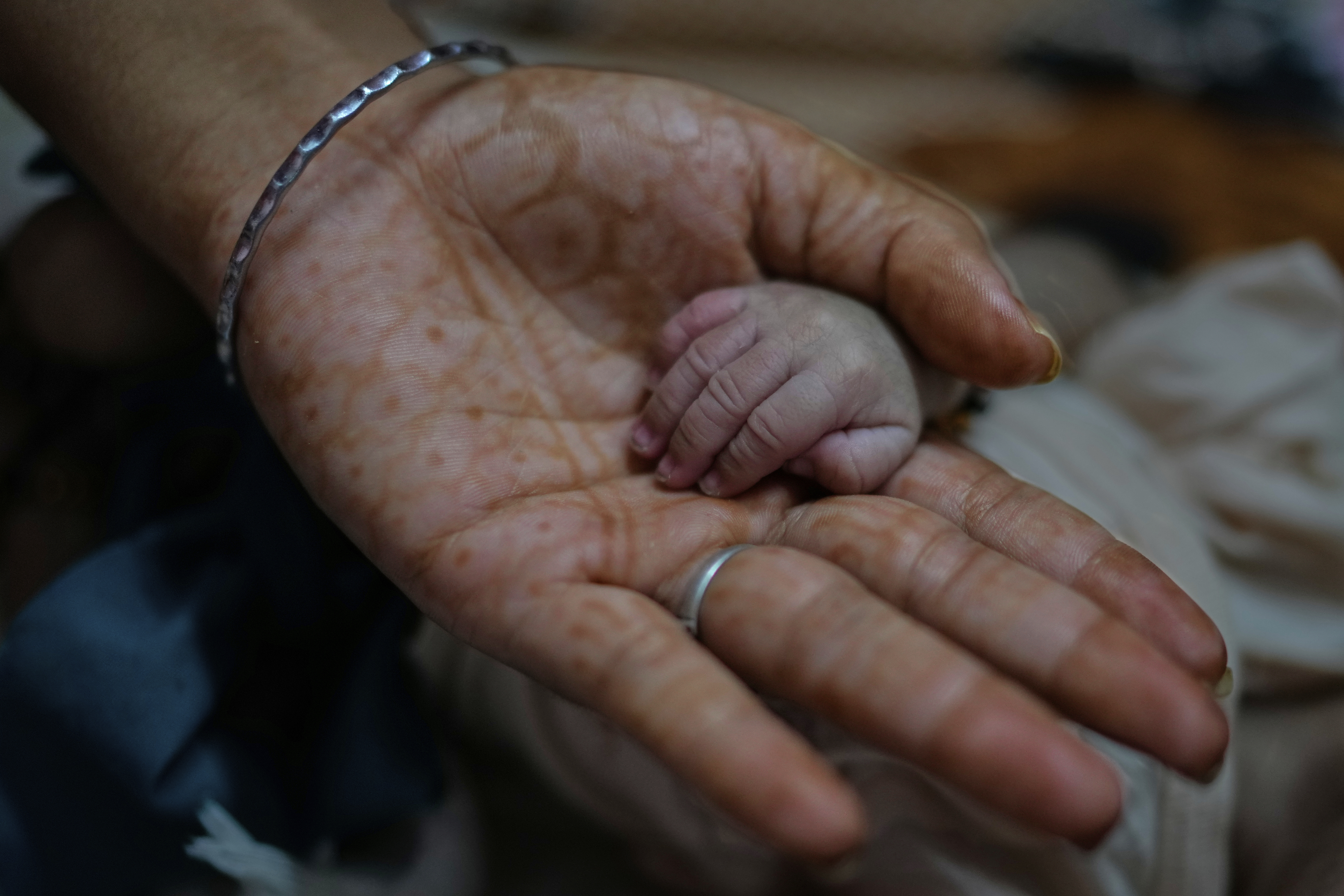 Antima Kumari holds the hand of her newborn nephew at their house in Gurugram, a satellite city of New Delhi, India, Friday, Aug. 8, 2025. (Manish Swarup - AP)