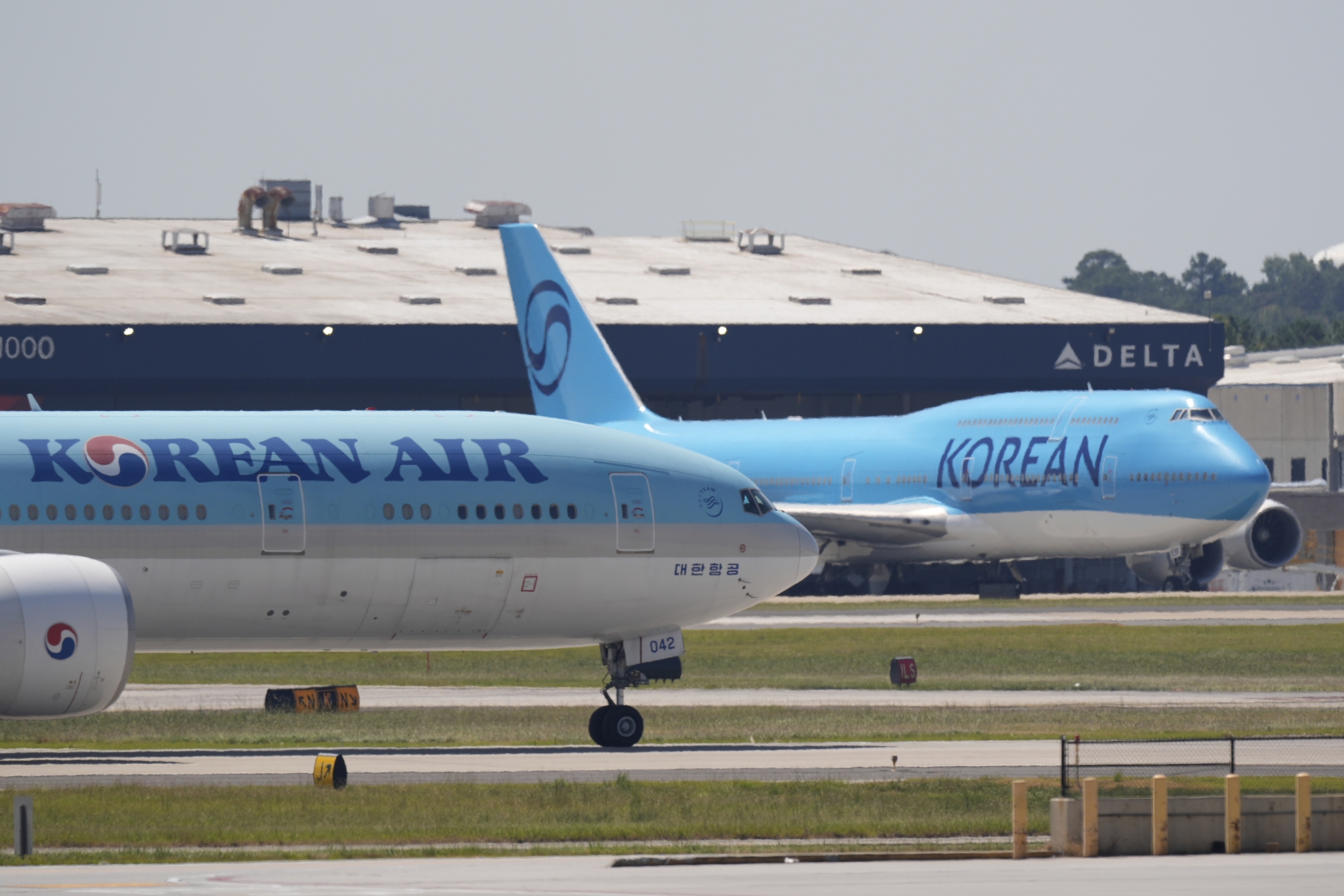 A Korean Air passenger plane, left, takes off while a charter plane right, is parked at Hartsfield-Jackson International Airport in Atlanta, Wednesday, Sept. 10, 2025, in Atlanta. (Mike Stewart - AP)