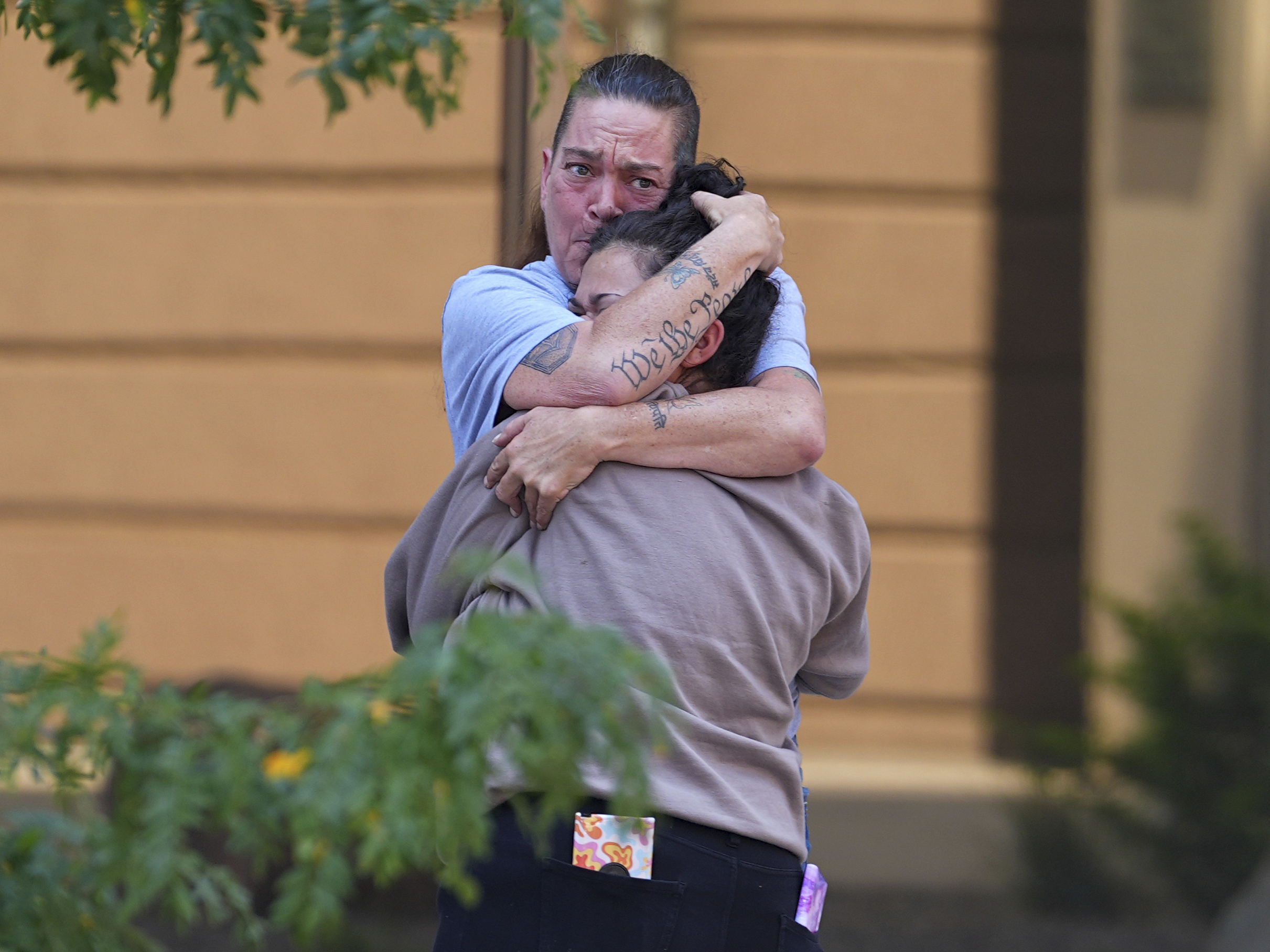 Crystina Page, back, hugs a well-wisher outside the El Paso County Courthouse after a judge ruled against accepting a plea deal in the case of a funeral home owner who stored roughly 189 decomposing bodies in a building Friday, Aug. 22, 2025, in Colorado Springs, Colo. (David Zalubowski - AP)