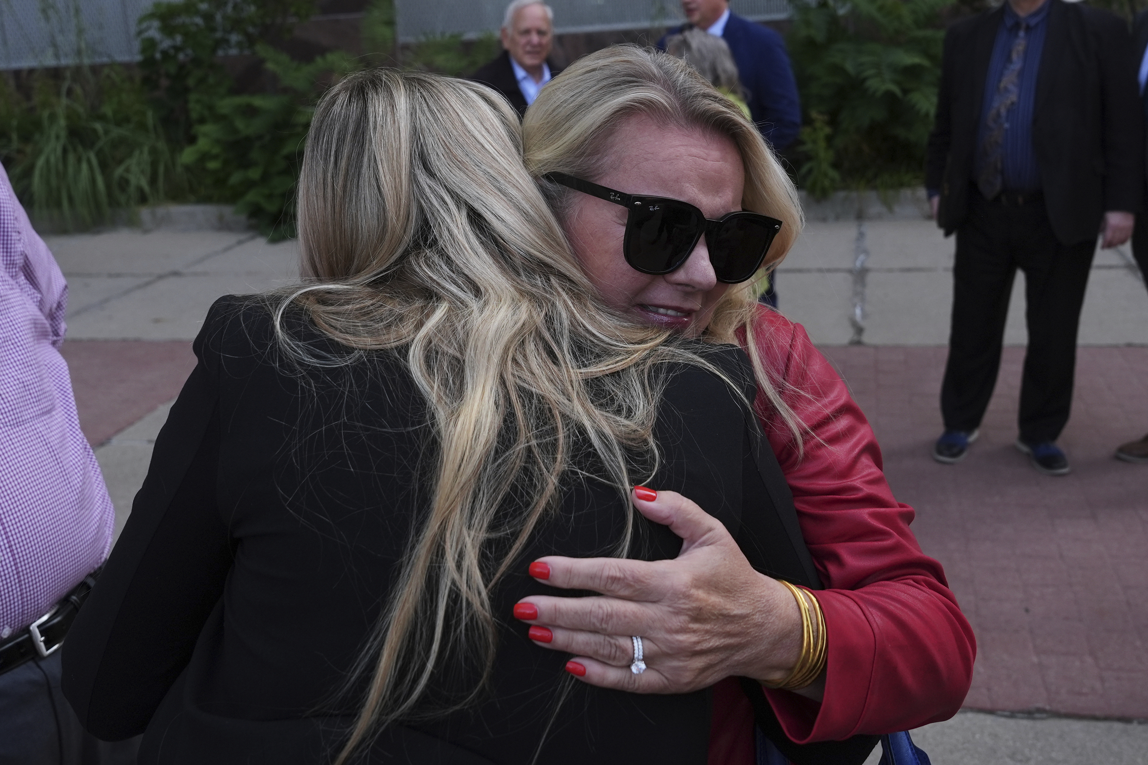 Meshawn Maddock receives a hug after a Michigan judge dismissed the criminal cases against 15 people accused of acting falsely as electors for President Donald Trump in the 2020 election Tuesday, Sept. 9, 2025 in Lansing, Mich. (Paul Sancya - AP)