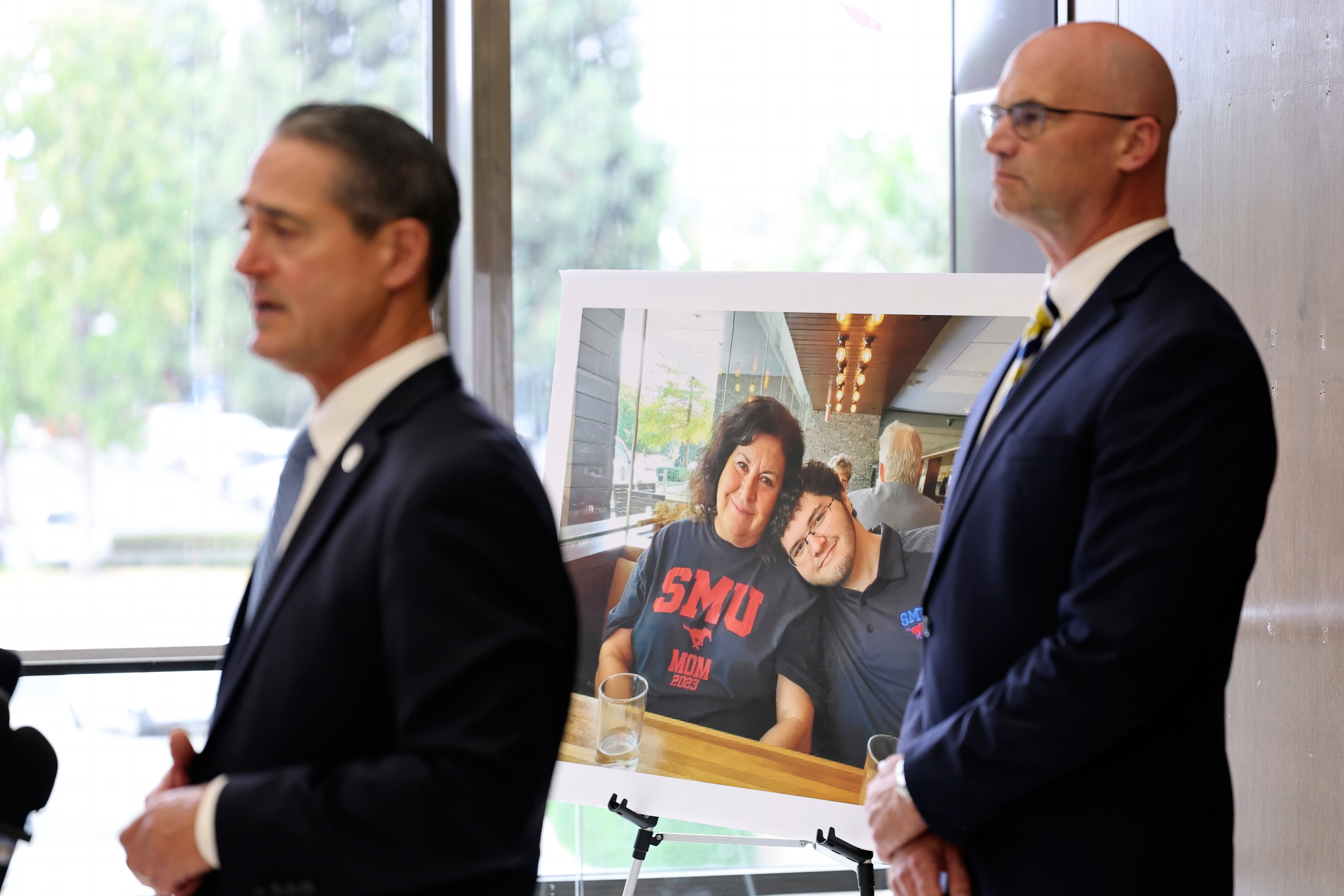 A photo of Sheryl Ferguson, the wife and son Phillip Ferguson of Orange County Superior Judge Jeffrey Ferguson is displayed as Orange County District Attorney Todd Spitzer, left, and Senior Deputy District Attorneys Seton Hunt speak to the media after Orange County Superior Court Judge Jeffrey Ferguson was sentenced to 35 years to life in prison after his second-degree murder conviction for shooting his wife, at the Central Justice Center in Santa Ana, Calif., Wednesday, Sept. 17, 2025. (Allen J. Schaben - Pool Los Angeles Times)